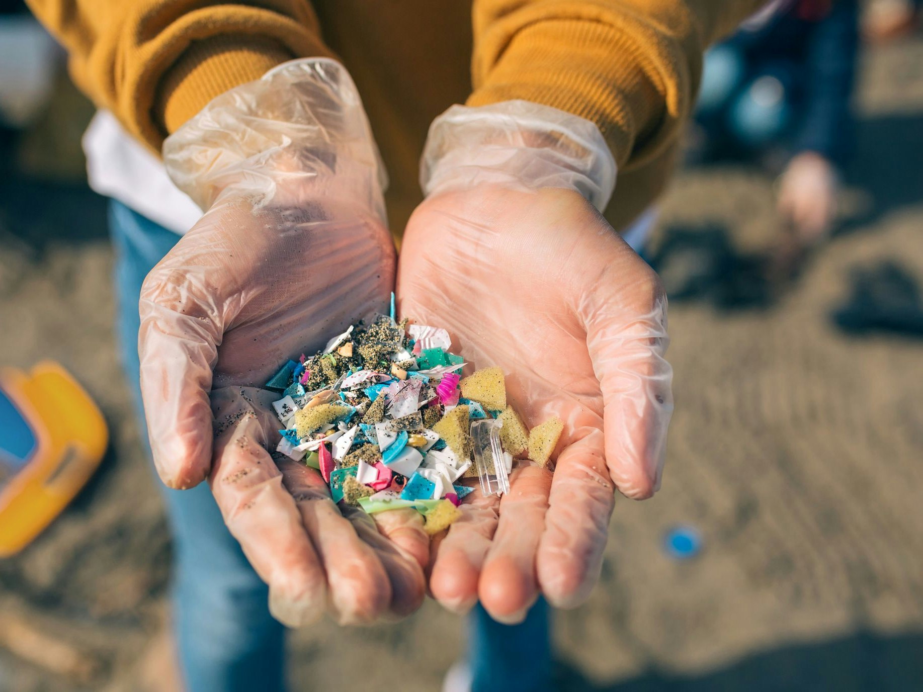 Detail of hands showing microplastics on the beach