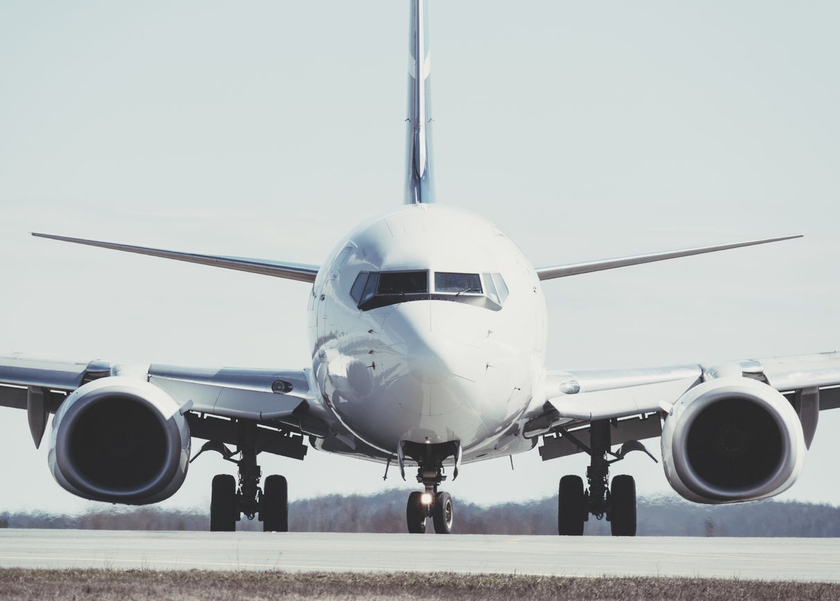 A passenger jet taxis towards an airport gate after landing.