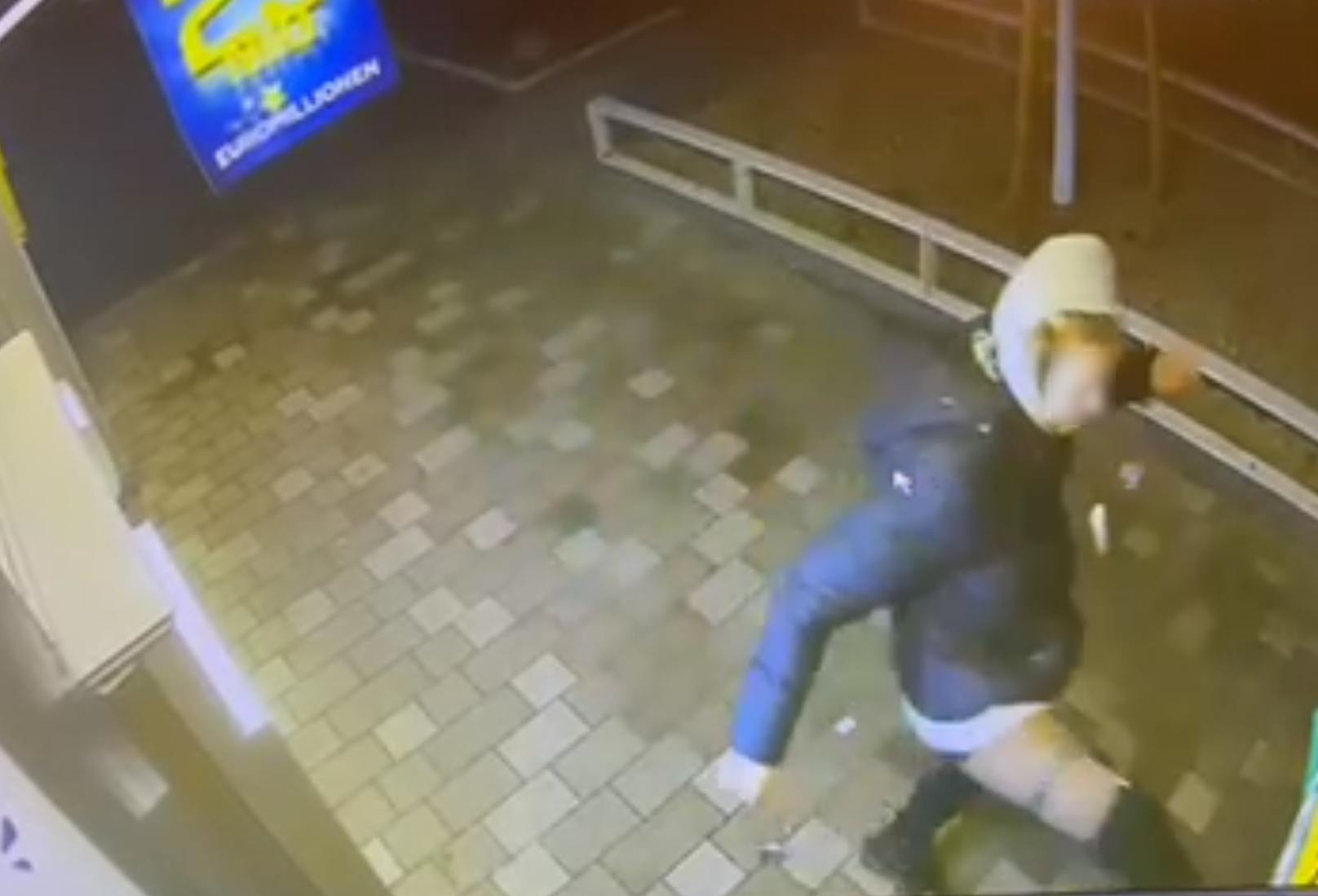 Zuerst schlug eine Frau mit dem rechten Bein grundlos in eine Holzabgrenzung der Pizzeria.