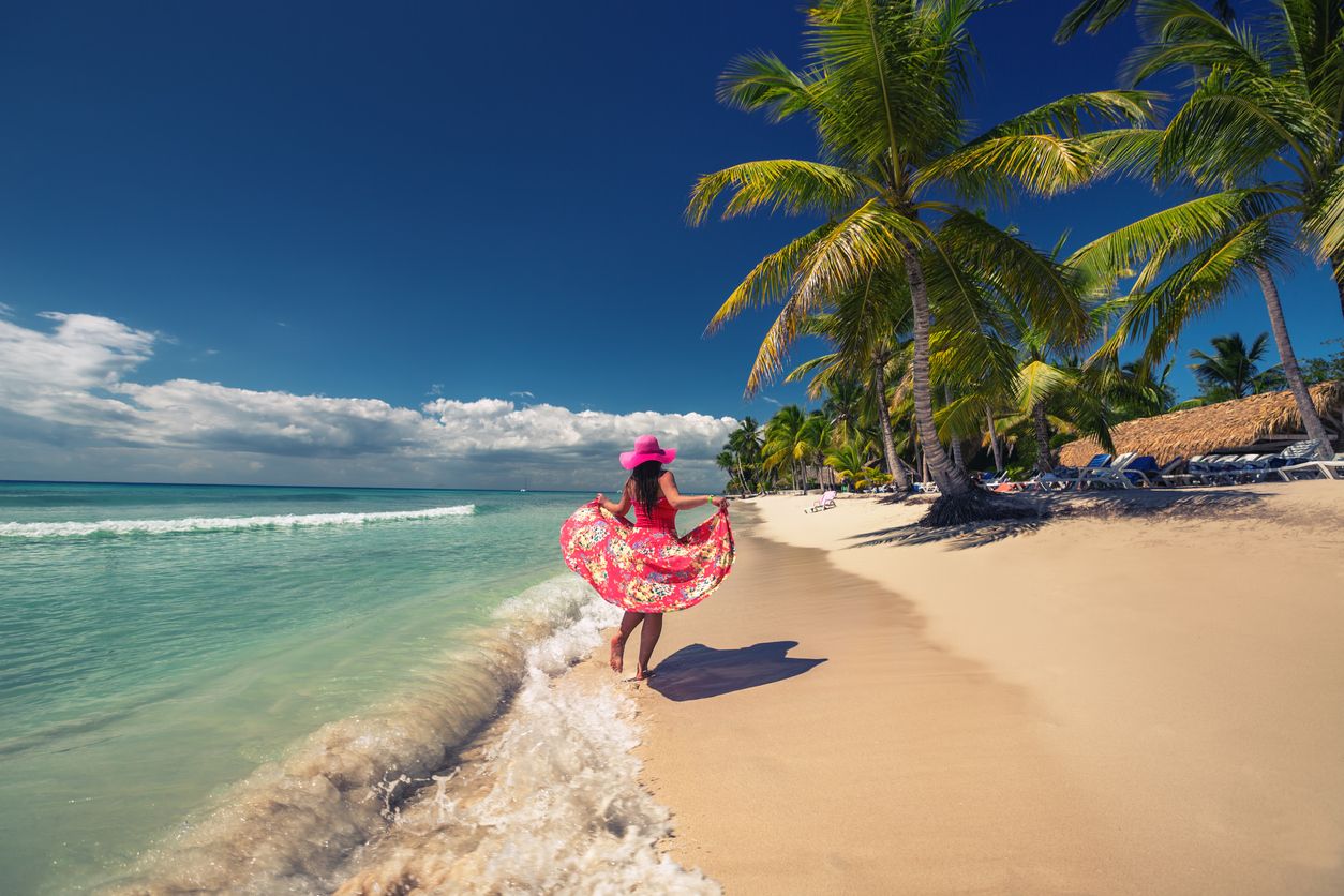 Carefree young woman  walking on the tropical sandy beach, Saona island, Dominican Republic