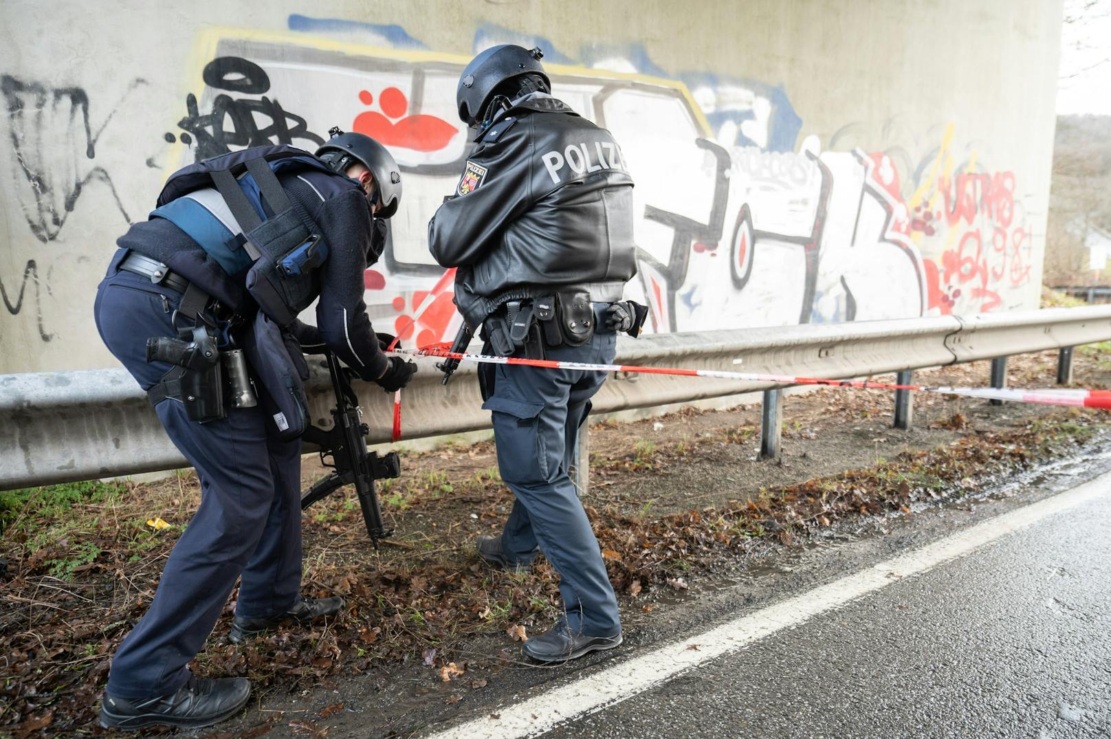 Die Straße am Tatort ist aktuell großräumig abgesperrt: Schwer bewaffnete Polizisten sichern das Gelände.&nbsp;