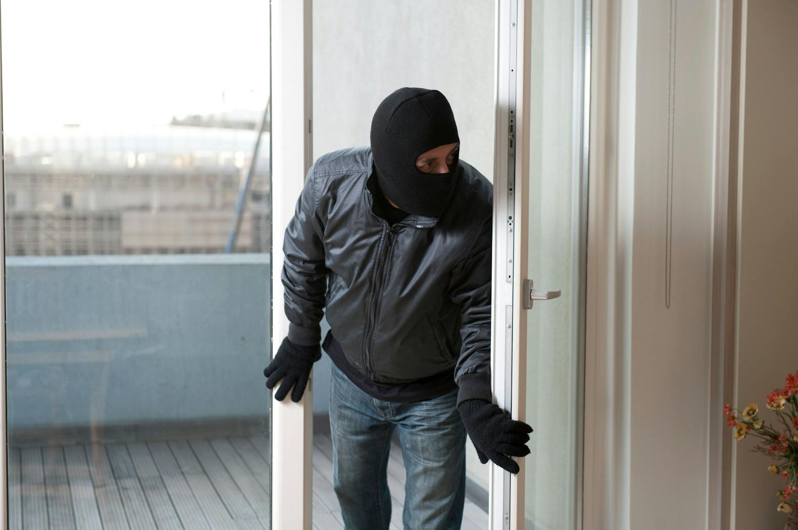 Ein maskierter Mann bricht in eine Wohnung ein. (Symbolfoto)