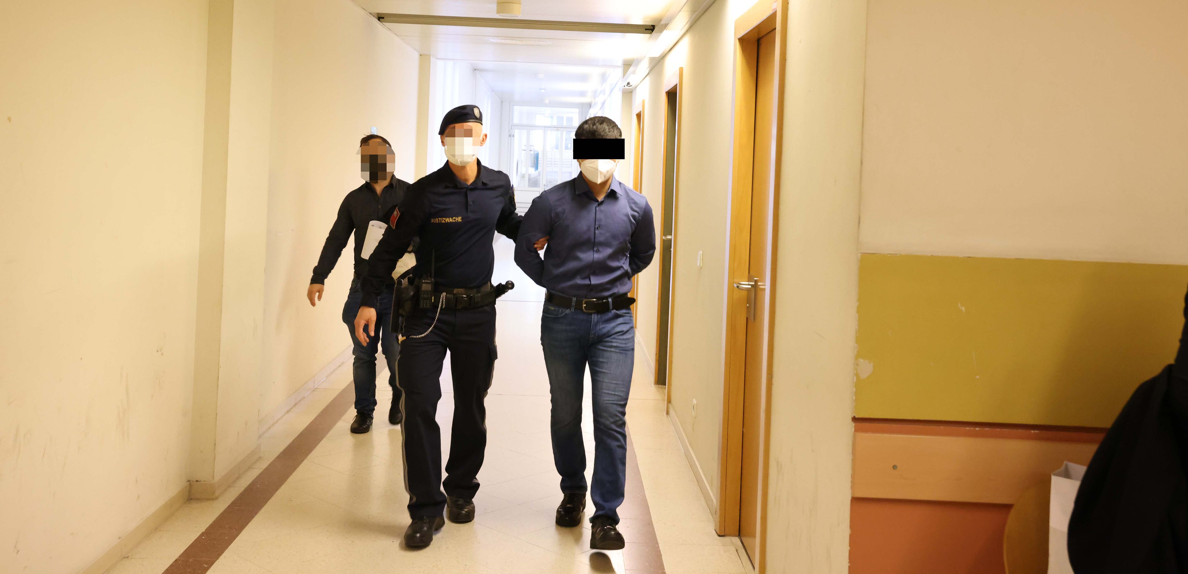 Der Angeklagte wird in den Gerichtssaal gebracht.
