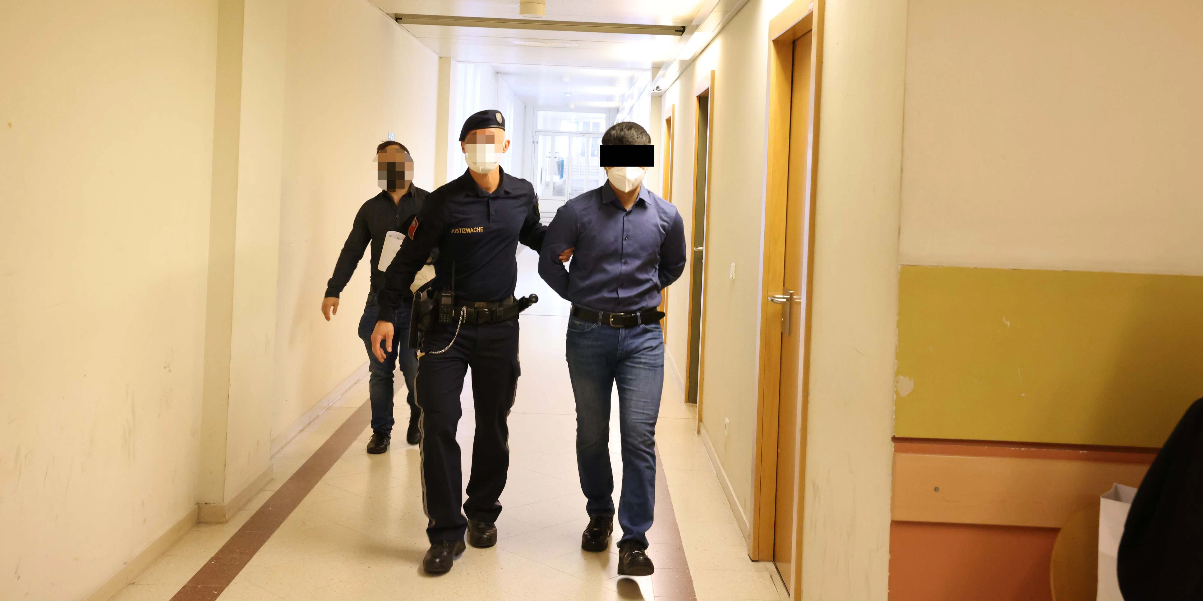 Der Angeklagte wird in den Gerichtssaal gebracht.