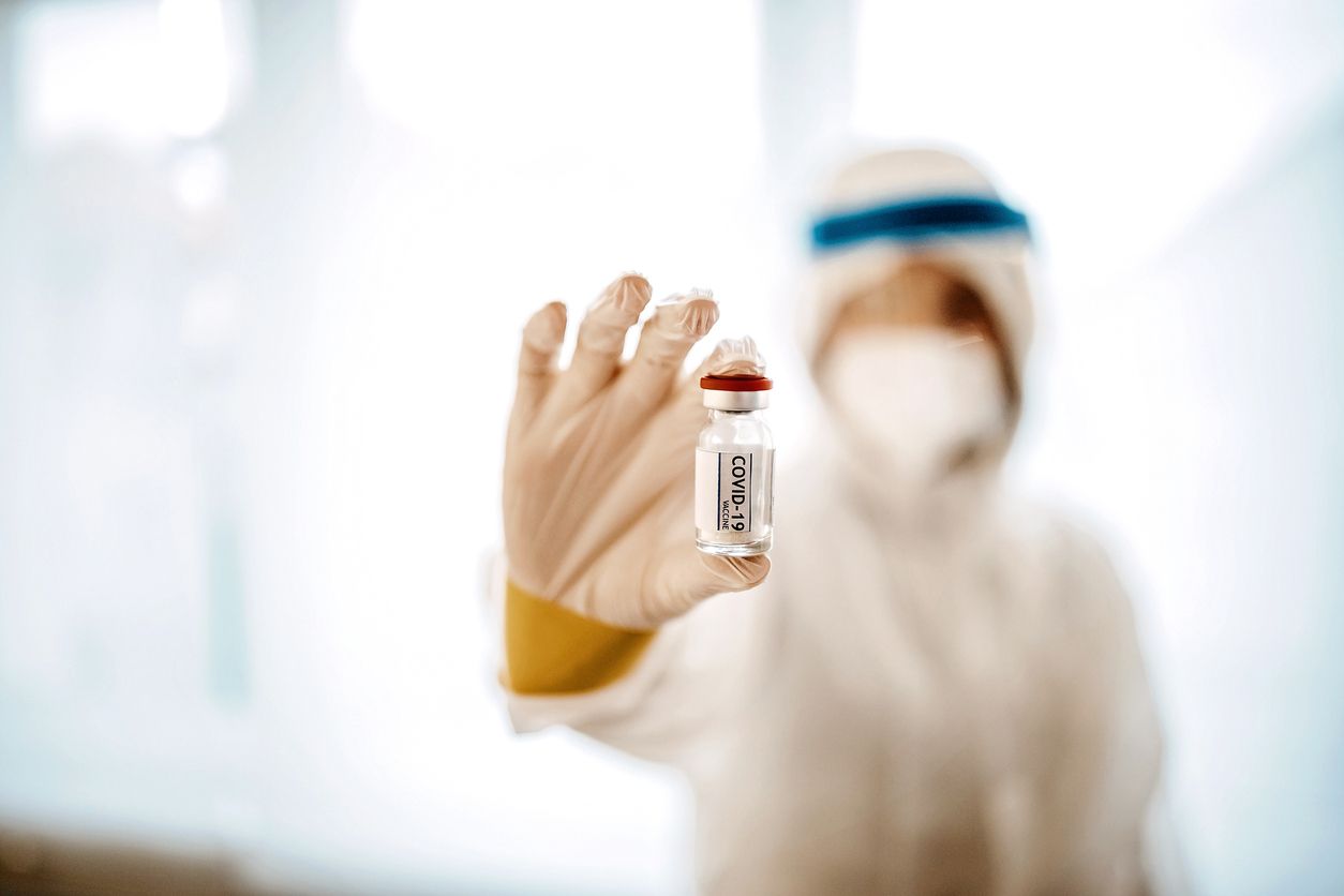 Nurse putting coronavirus vaccine into injection to give it to patient