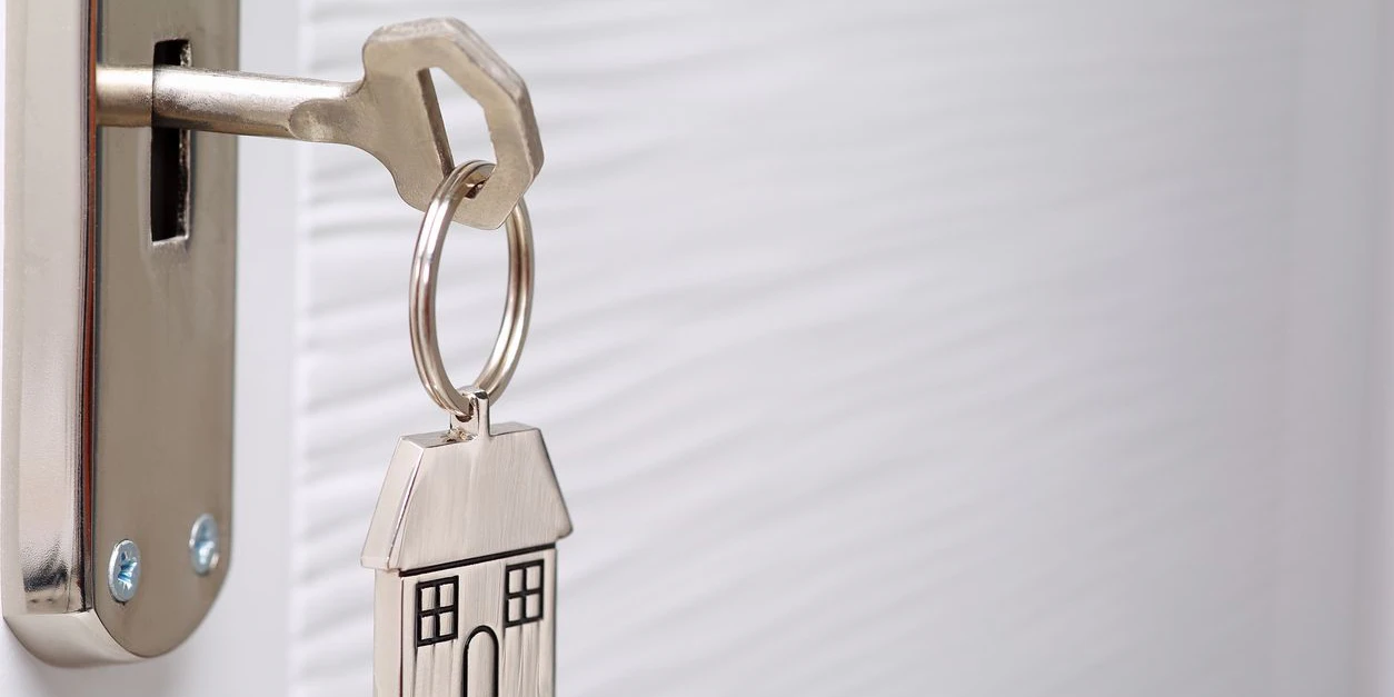 Home key with metal house keychain in keyhole