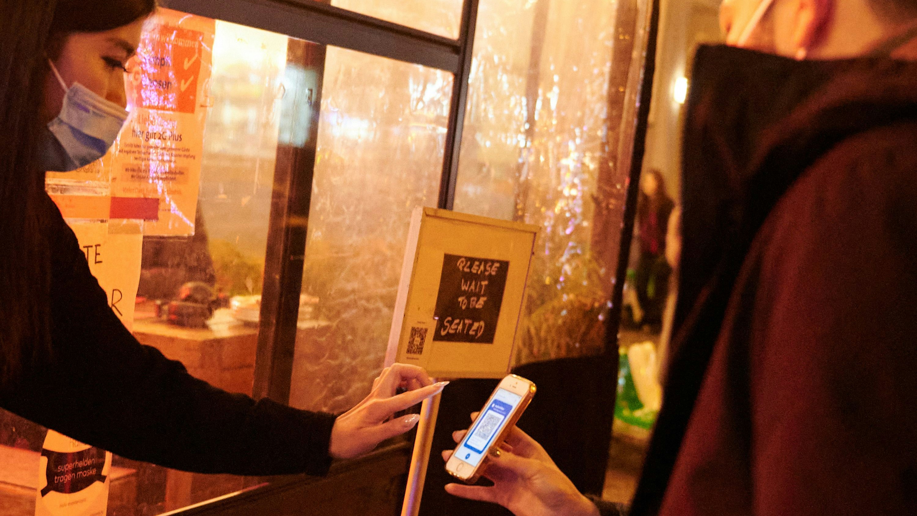 Download von www.picturedesk.com am 18.02.2022 (15:39).  15 January 2022, Berlin: A restaurant employee checks the vaccination status of two people. On January 15, stricter Corona rules came into force in Berlin. New measures include the 2GPlus rule in restaurants and the FFP2 mask requirement in buses and trains. Photo: Annette Riedl/dpa - 20220115_PD13906 - Rechteinfo: Rights Managed (RM)