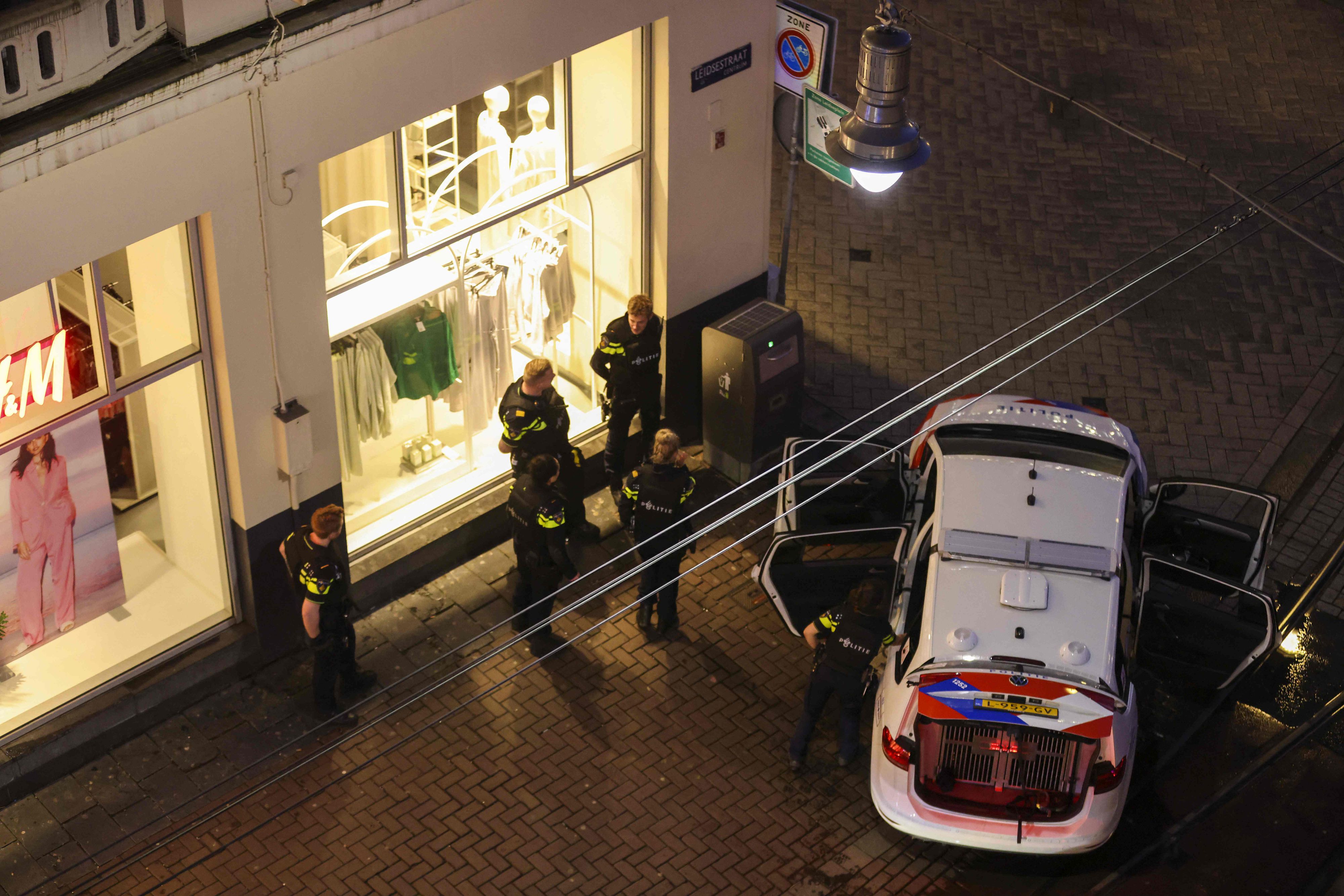 Download von www.picturedesk.com am 22.02.2022 (21:44).  Police officers by a police vehicle near Leidseplein during an hostage situation in an Amsterdam's Apple Store on February 22, 2022. - A man with a firearm was in the vicinity of an Amsterdam shop, police in the Netherlands said February 22, 2022 adding that officers were at the scene said by local media to be an Apple store. (Photo by Laurens Bosch / ANP / AFP) / Netherlands OUT - 20220222_PD7977 - Rechteinfo: Rights Managed (RM) Nur für redaktionelle Nutzung! Werbliche Nutzung erfordert Freigabe: bitte schicken Sie uns eine Anfrage.