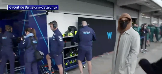 Lewis Hamilton streift vermummt durch die Boxengasse, inspiziert die Boliden der anderen Teams.