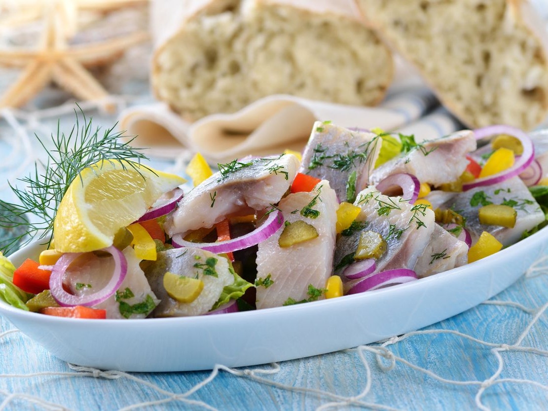 Delicious salad of salted fillets of white herring served with ciabatta bread