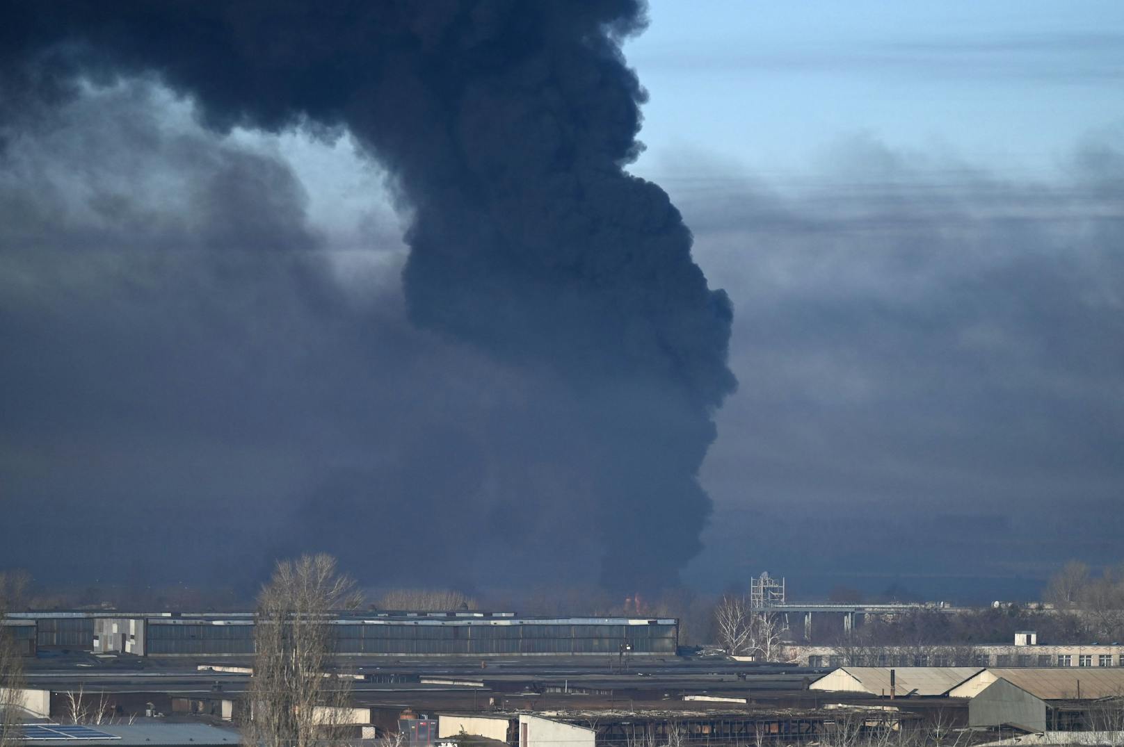 Eine schwarze Rauchsäule steigt von einem Militärflughafen nahe Charkiw auf – Russland hat einen Großangriff auf die Ukraine begonnen. (24. Februar, 2022)