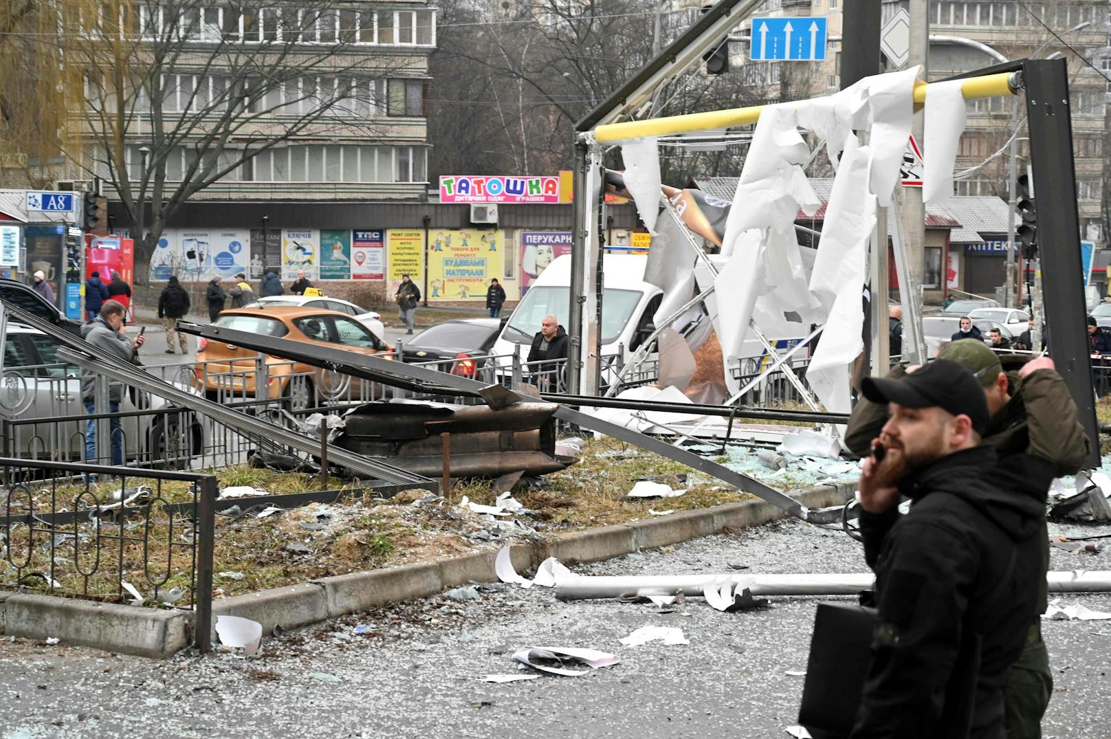 Passanten neben einer Einschlagstelle russischen Bombardements in Kiew.