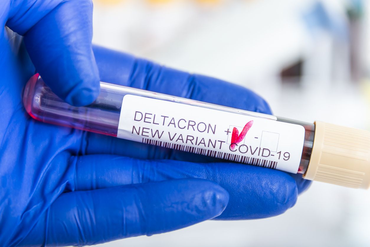 Researcher with blood sample of New Variant of the Covid-19 DELTACRON and generic data of covid-19 Coronavirus Mutations. Doctor in analysis lab holding sample of new strain of covid DELTACRON