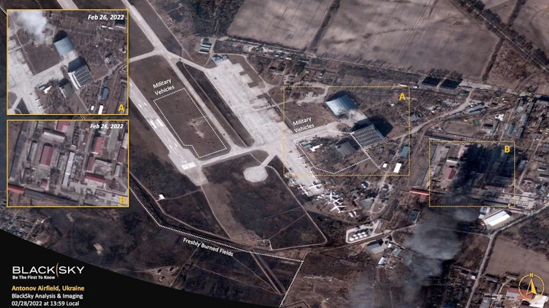 Das Satellitenbild zeigt den zerstörten ehemaligen Hangar der Antonov An-225 Mriya nördlich von Militärfahrzeugen, die sich um die Haupthangars gruppieren, und ein stationäres Flugzeug im Süden sowie nahegelegene Lagerhäuser, die aufgrund des anhaltenden Konflikts in der Region in Flammen stehen.