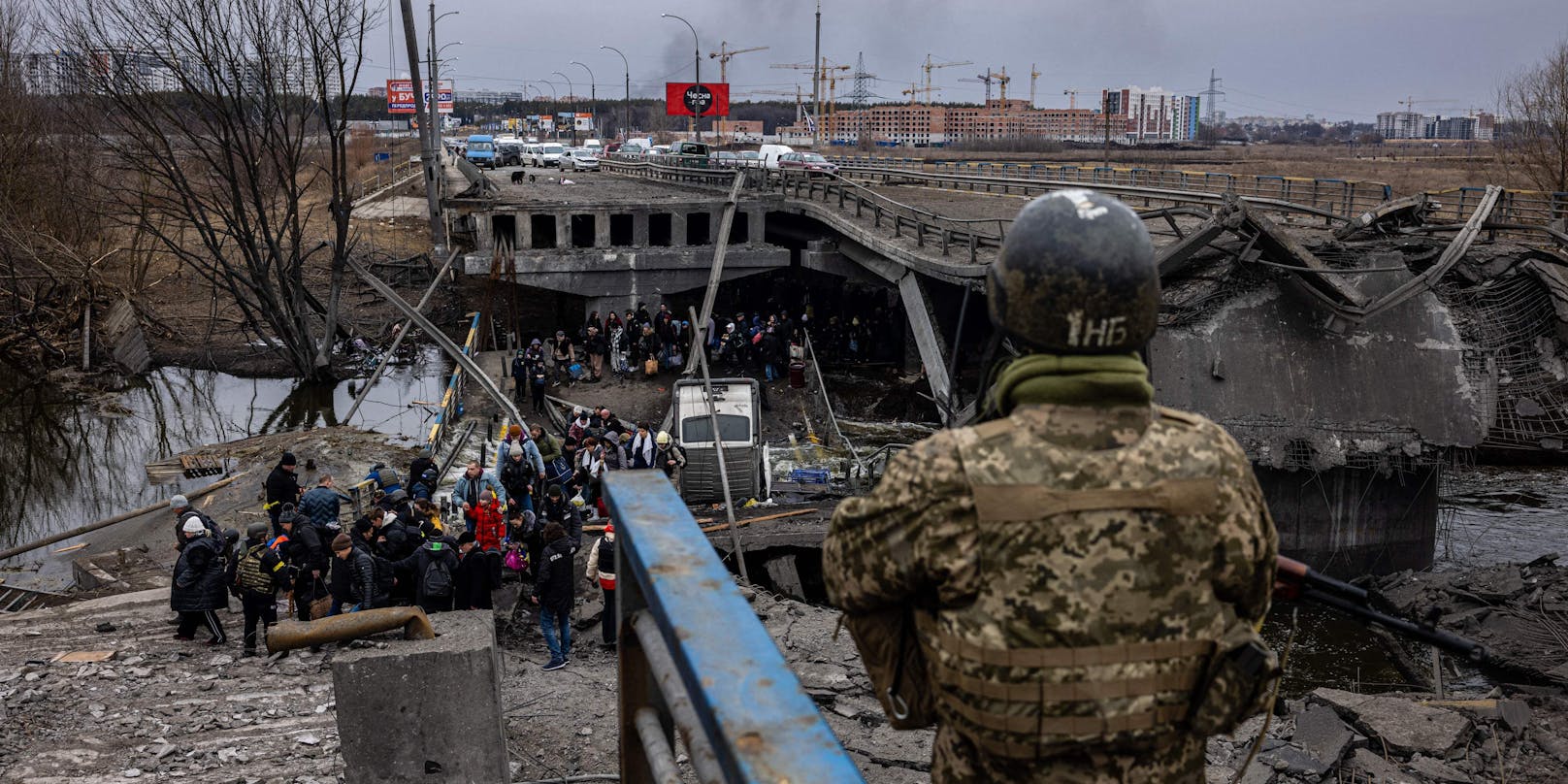 Flüchtende Ukrainerinnen und Ukrainer beim Überqueren einer zerstörten Brücke in der nordwestlich von Kiew gelegenen Stadt Irpin.