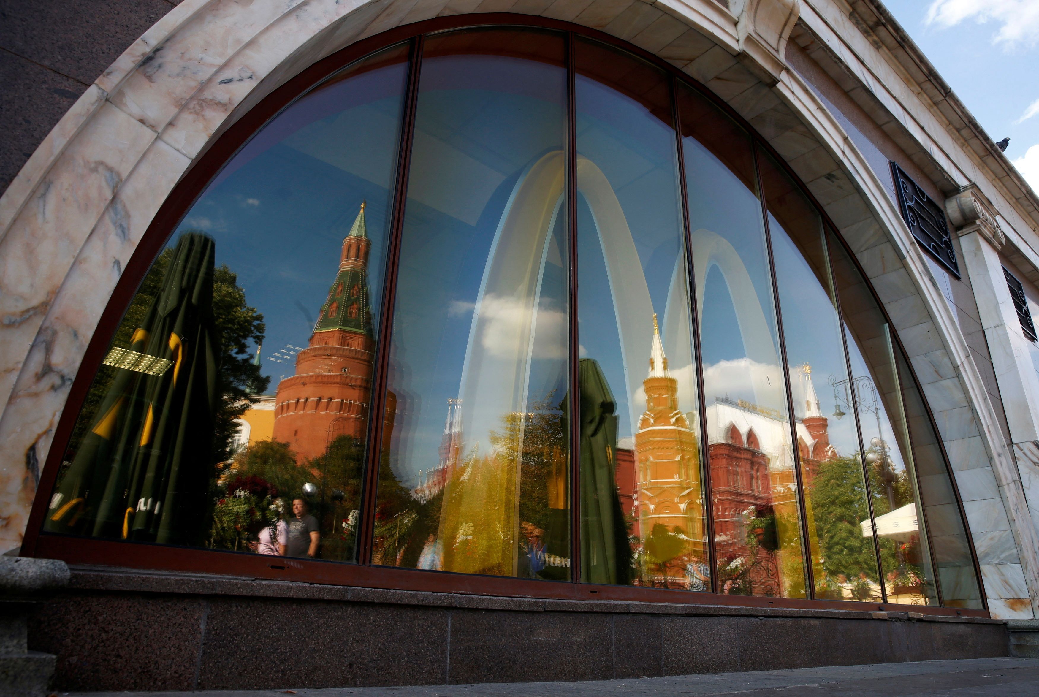 Die Türme des Kremls spiegeln sich in den Fensterscheiben einer McDonald's-Filiale nahe des Roten Platzes in Moskau. Nach scharfer Kritik kündigte der Fastfood-Konzern am Dienstag an, alle Filialen zu schließen.