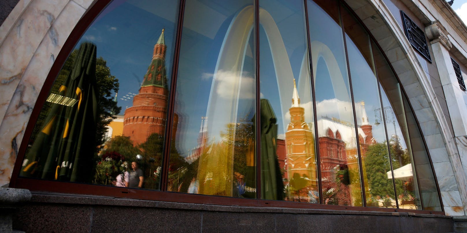 Die Türme des Kremls spiegeln sich in den Fensterscheiben einer McDonald's-Filiale nahe des Roten Platzes in Moskau. Nach scharfer Kritik kündigte der Fastfood-Konzern am Dienstag an, alle Filialen zu schließen.