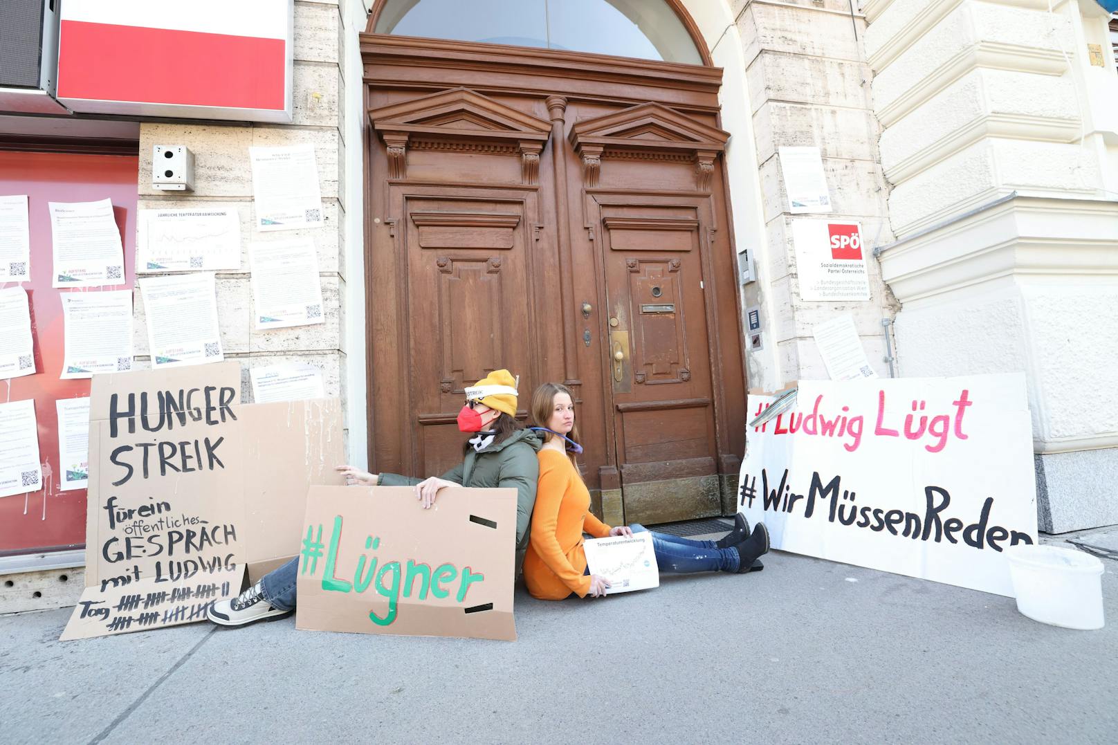Zwei Aktivistinnen ketteten sich vor der SPÖ-Parteizentrale aneinander. Sie fordern den Abbruch der Arbeiten an der Stadtstraße.