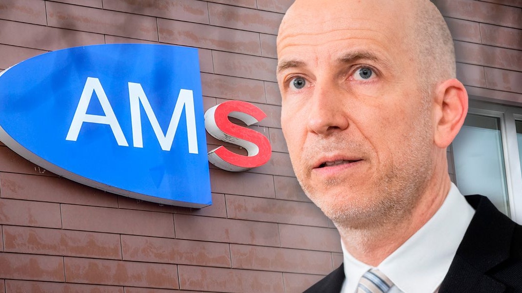 Arbeitsminister Martin Kocher (VP) vor einem Logo des Arbeitsmarktservice AMS.