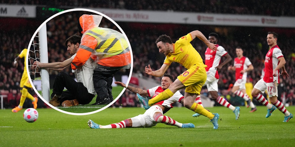 Ein Flitzer hält sich am Tor von Liverpool fest.