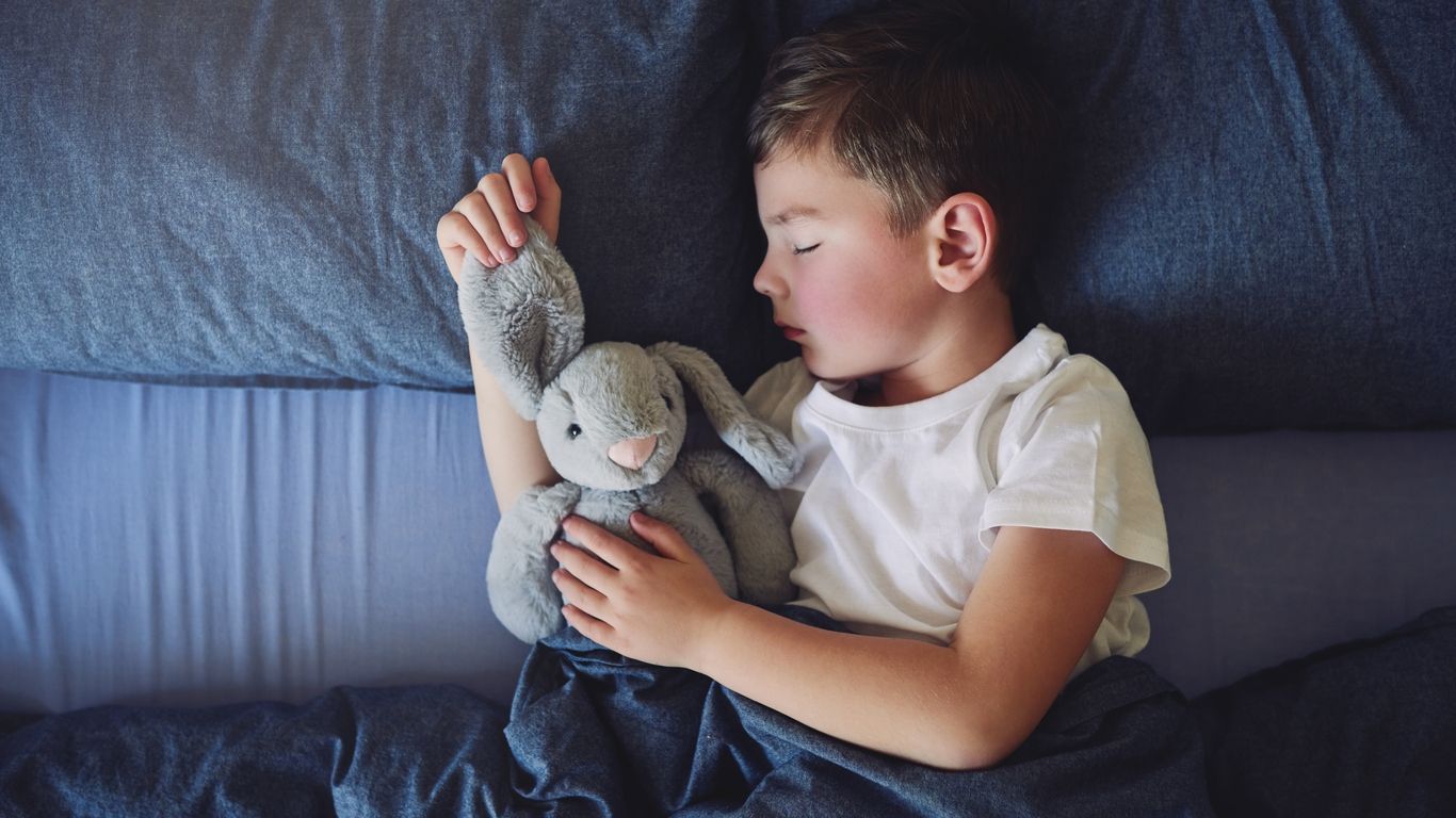 High angle shot of an adorable little boy sleeping in bed at home