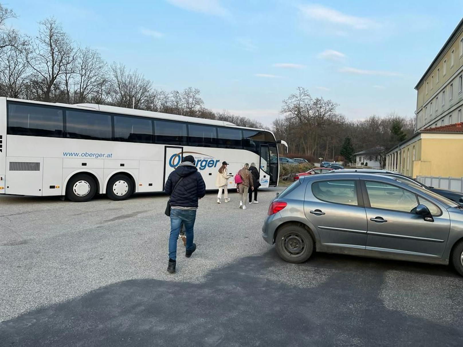 Flüchtlinge gehen zu Bus vor Hotel