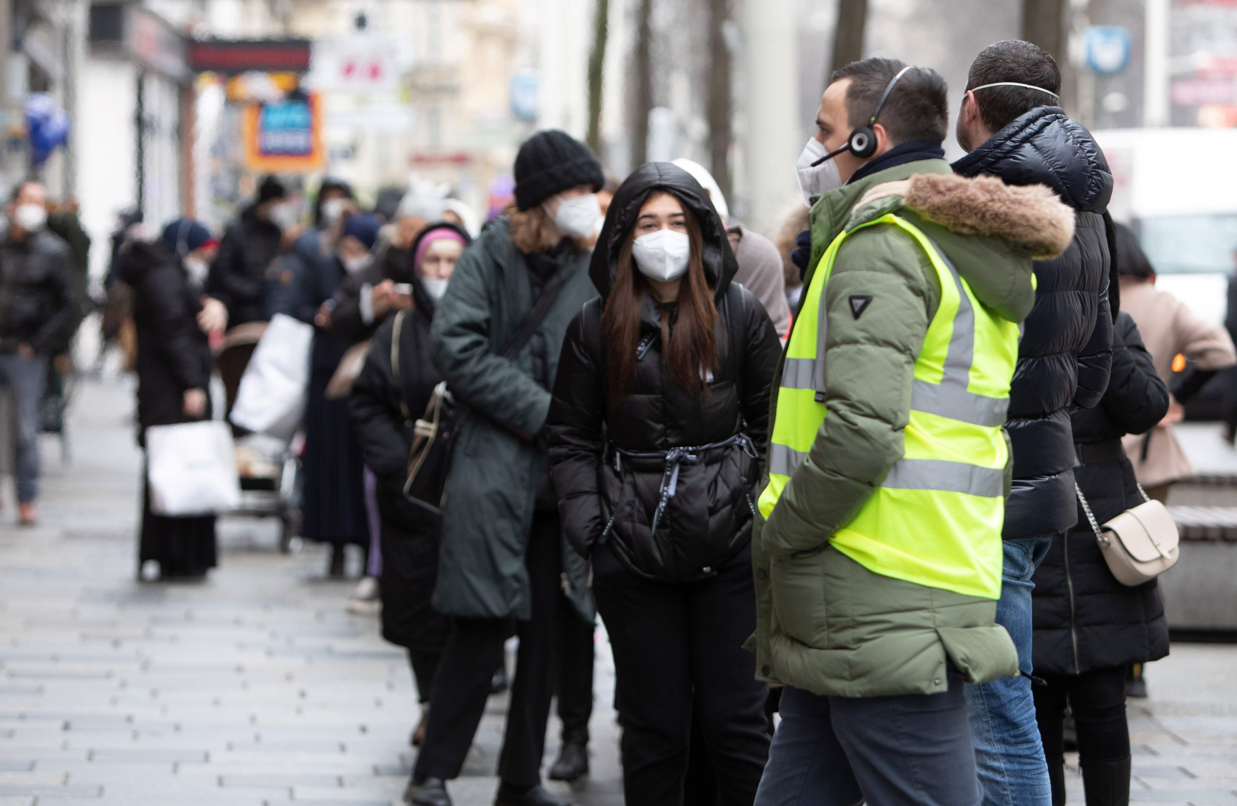 Download von www.picturedesk.com am 19.03.2022 (13:56).  A security staff looks on while people with FFP2 protective face masks wait in front of a shop in the well-known shopping street Mariahilferstrasse in Vienna on February 8, 2021. - Austria has ended the hard lockdown today and allowed services with the mandatory use of FFP2 protective masks and a negative coronavirus rapid antigen test. (Photo by ALEX HALADA / AFP) - 20210208_PD5697 - Rechteinfo: Rights Managed (RM) Nur für redaktionelle Nutzung! Werbliche Nutzung erfordert Freigabe: bitte schicken Sie uns eine Anfrage.