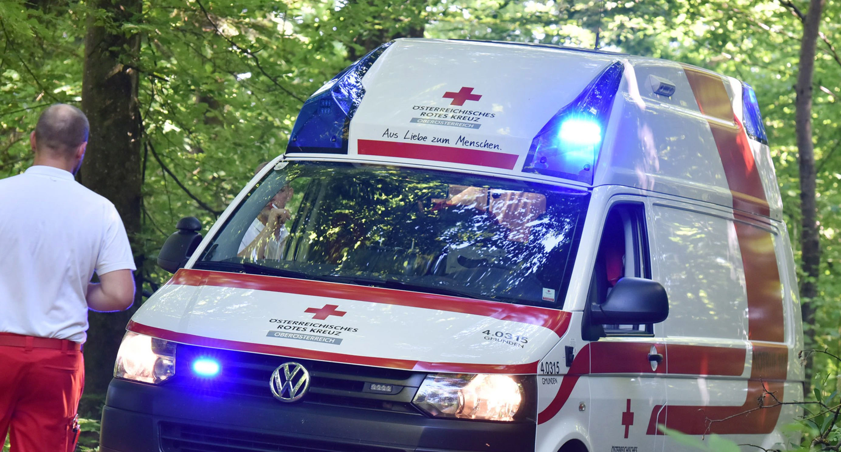 A red cross ambulance with blue lights in a wood, Austria, Europe