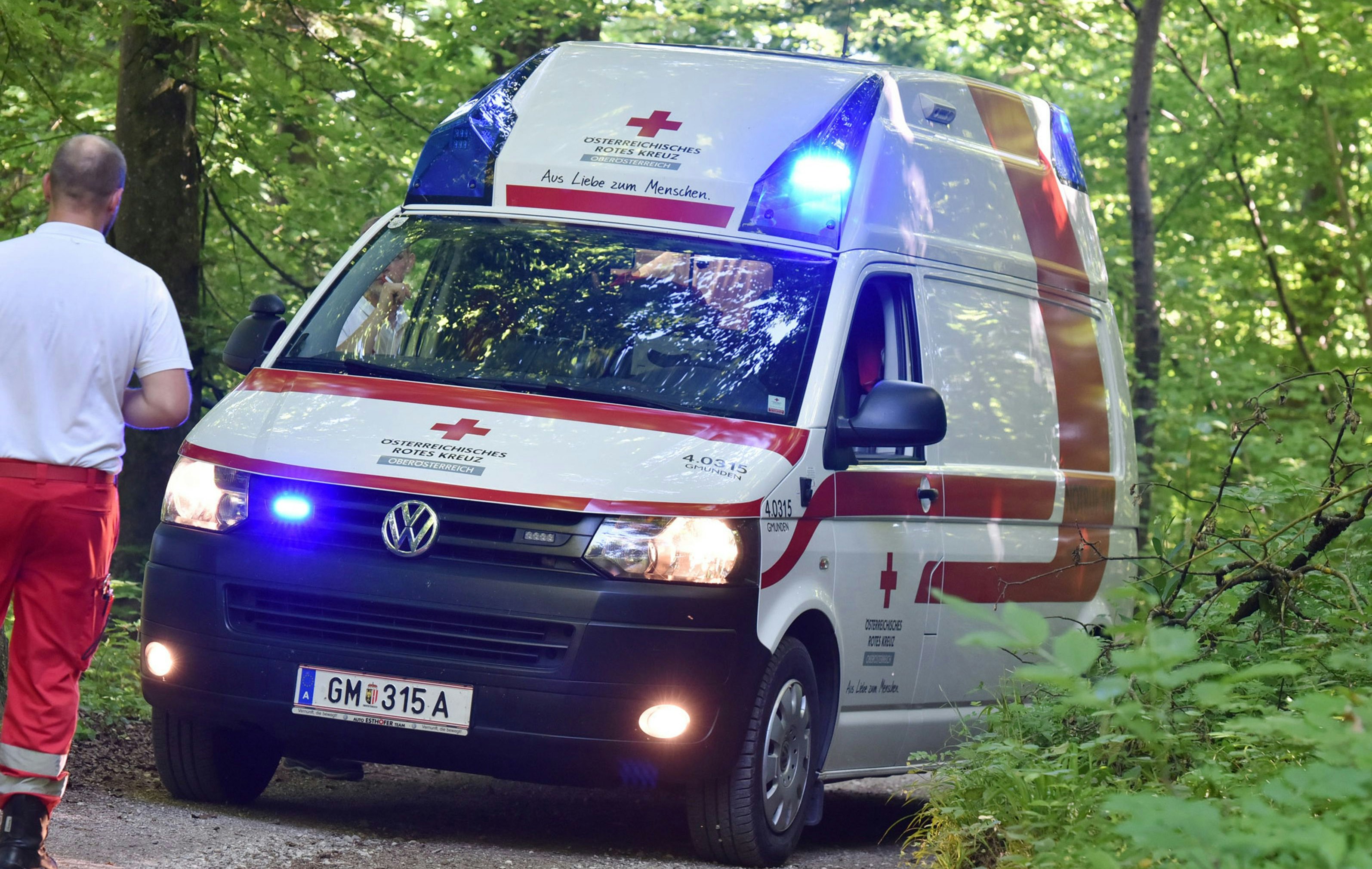 A red cross ambulance with blue lights in a wood, Austria, Europe