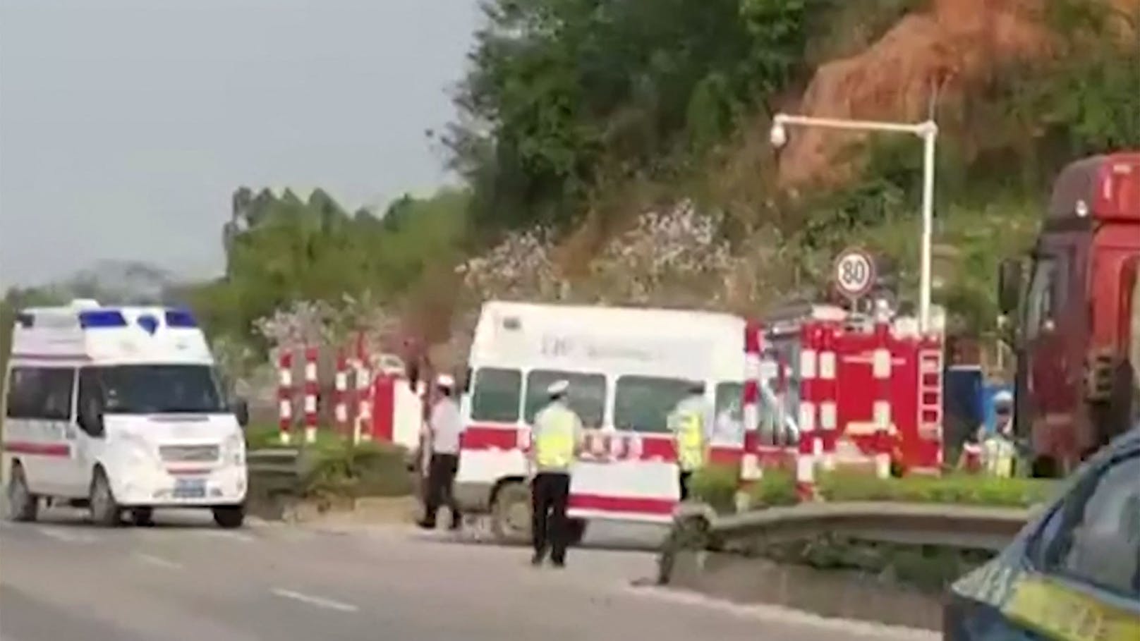 Einsatzkräfte am Weg zur Absturzstelle nahe Wuzhou.