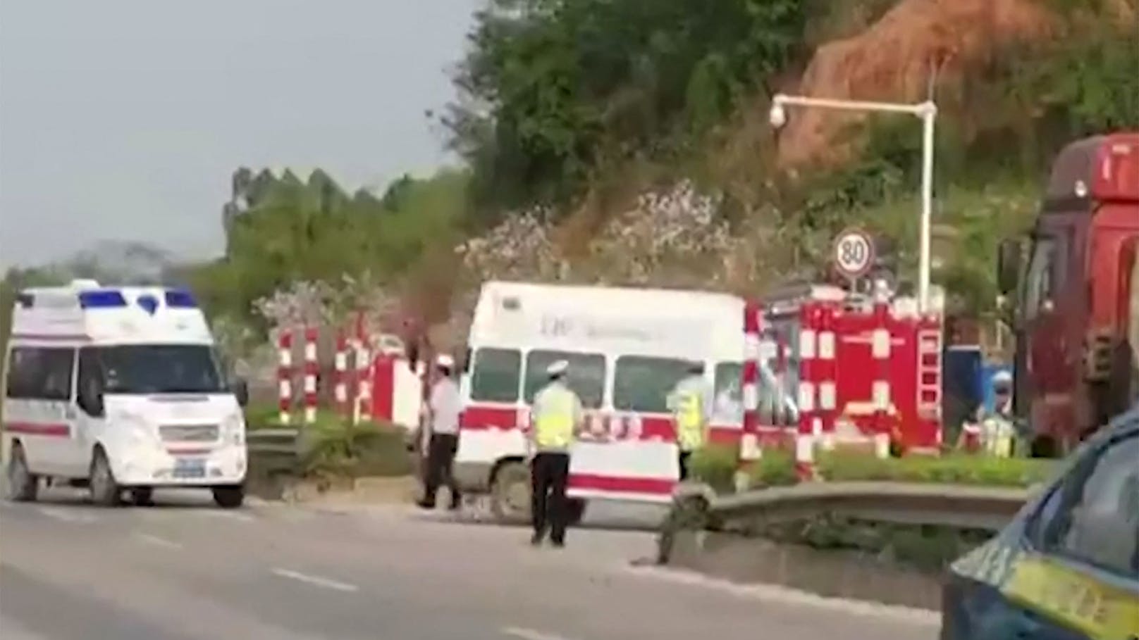 Einsatzkräfte am Weg zur Absturzstelle nahe Wuzhou.