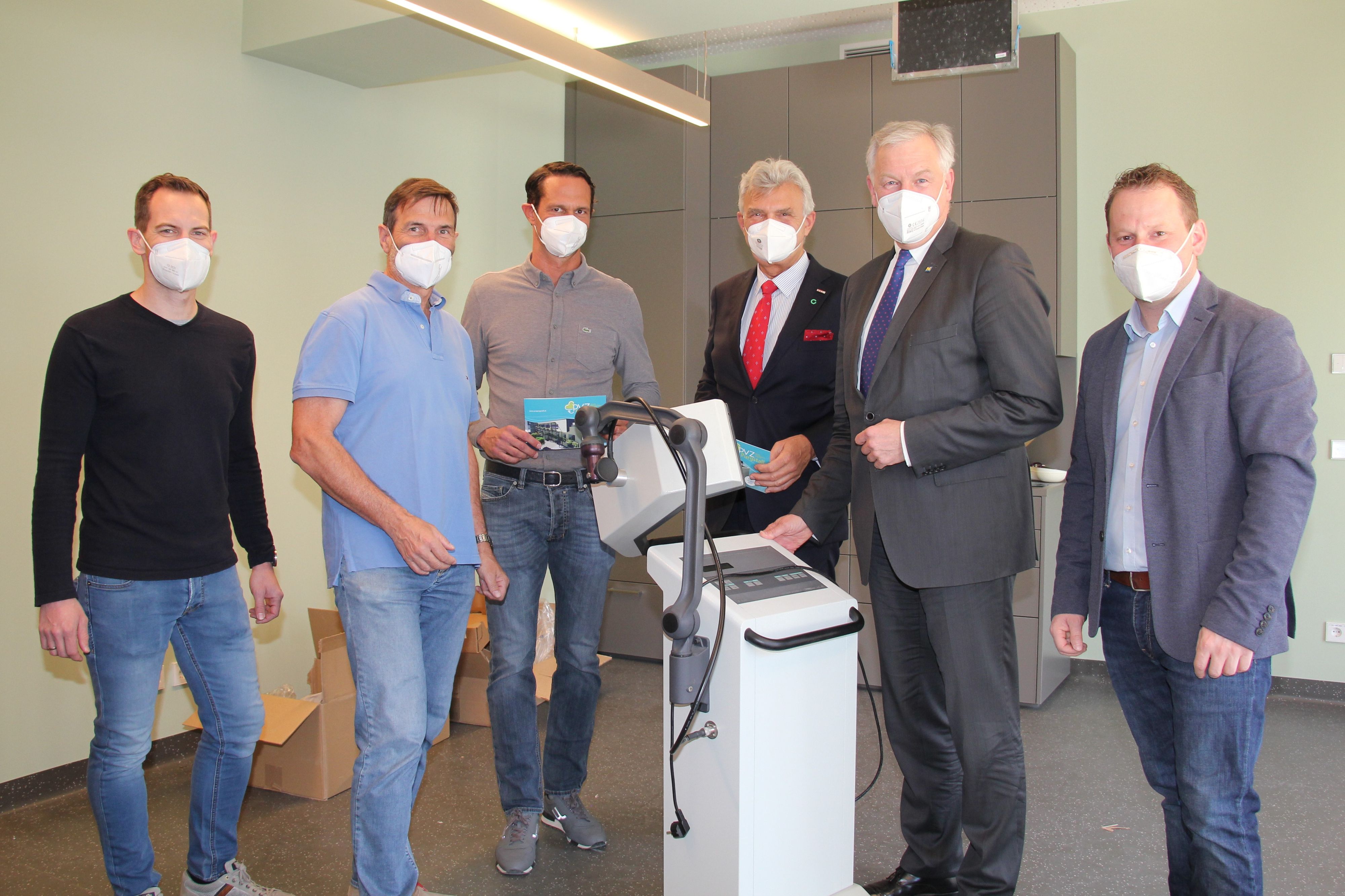 Dr. Thomas Bandur, Dr. Leopold Auer, Geschäftsführer Philipp Schramhauser, Norbert Fidler, Vorsitzender des Landesstellenausschusses der Österreichischen Gesundheitskasse in Niederösterreich, Landesrat und NÖGUS-Vorsitzender Martin Eichtinger und Bürgermeister Harald Riemer hinter einem Kurzwellengerät zur Wärmetherapie bzw. zum Aufwärmen vor einer Massage.