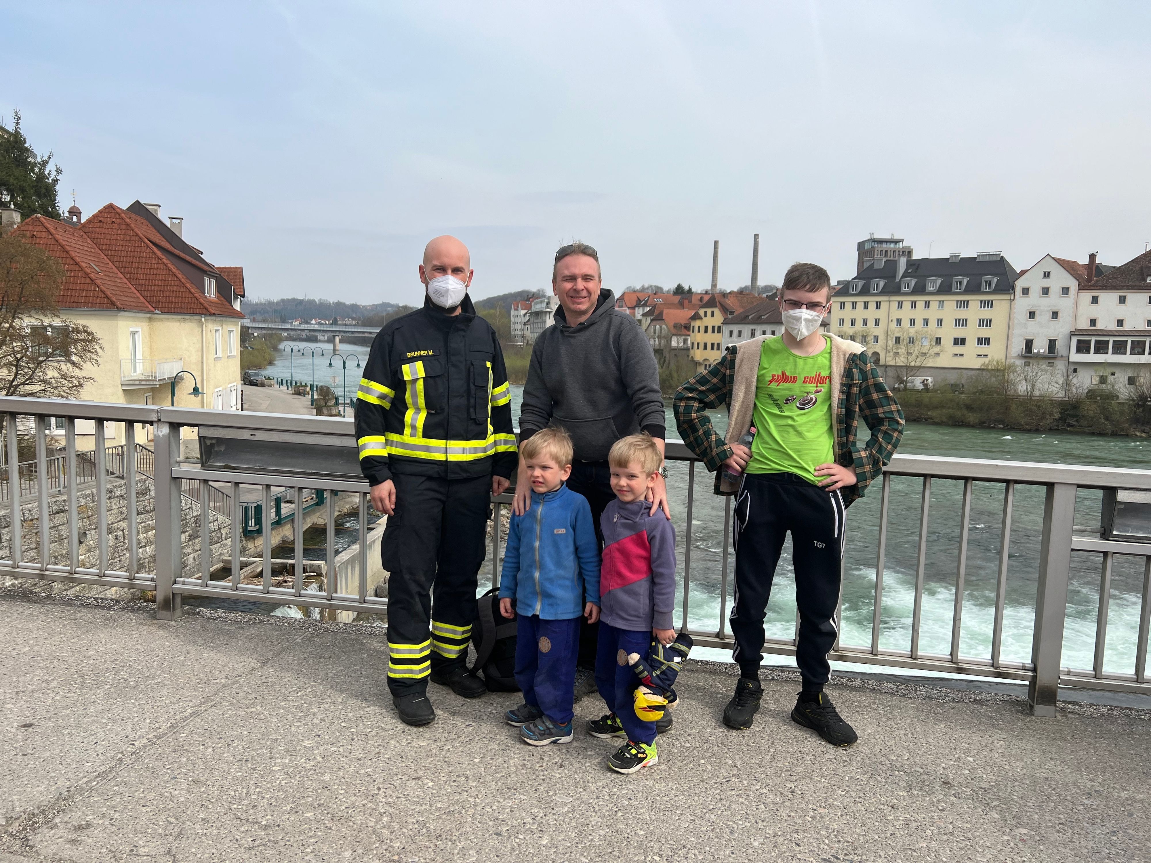 Der kleine Ilia (4, 2.v.re; mit Familie)) schaute mit dem Kopf durchs Brückengeländer, blieb stecken. Feuerwehrmann Manuel Brunner (li.) gehörte zum Rettungs-Team.