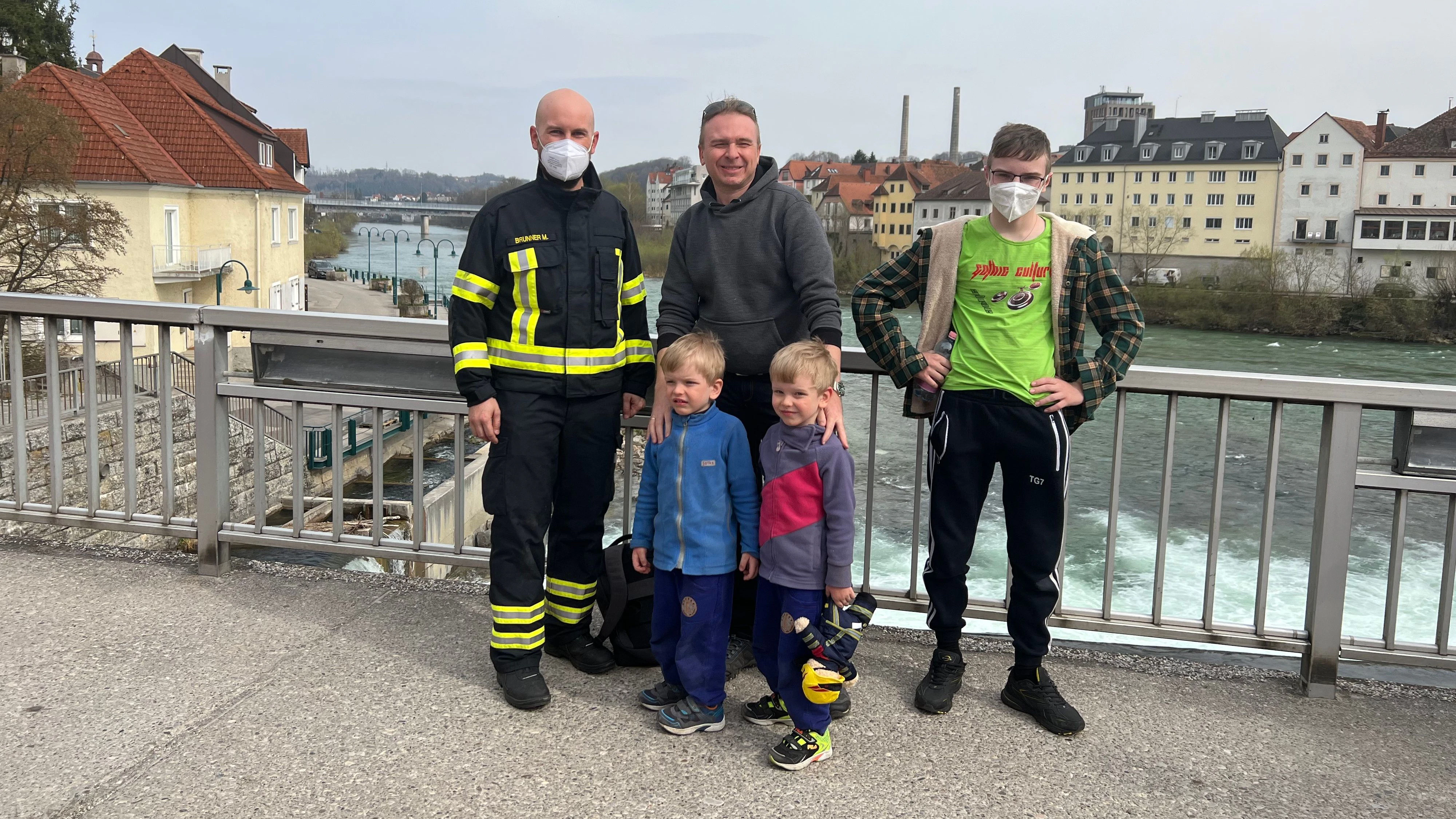 Der kleine Ilia (4, 2.v.re; mit Familie)) schaute mit dem Kopf durchs Brückengeländer, blieb stecken. Feuerwehrmann Manuel Brunner (li.) gehörte zum Rettungs-Team.