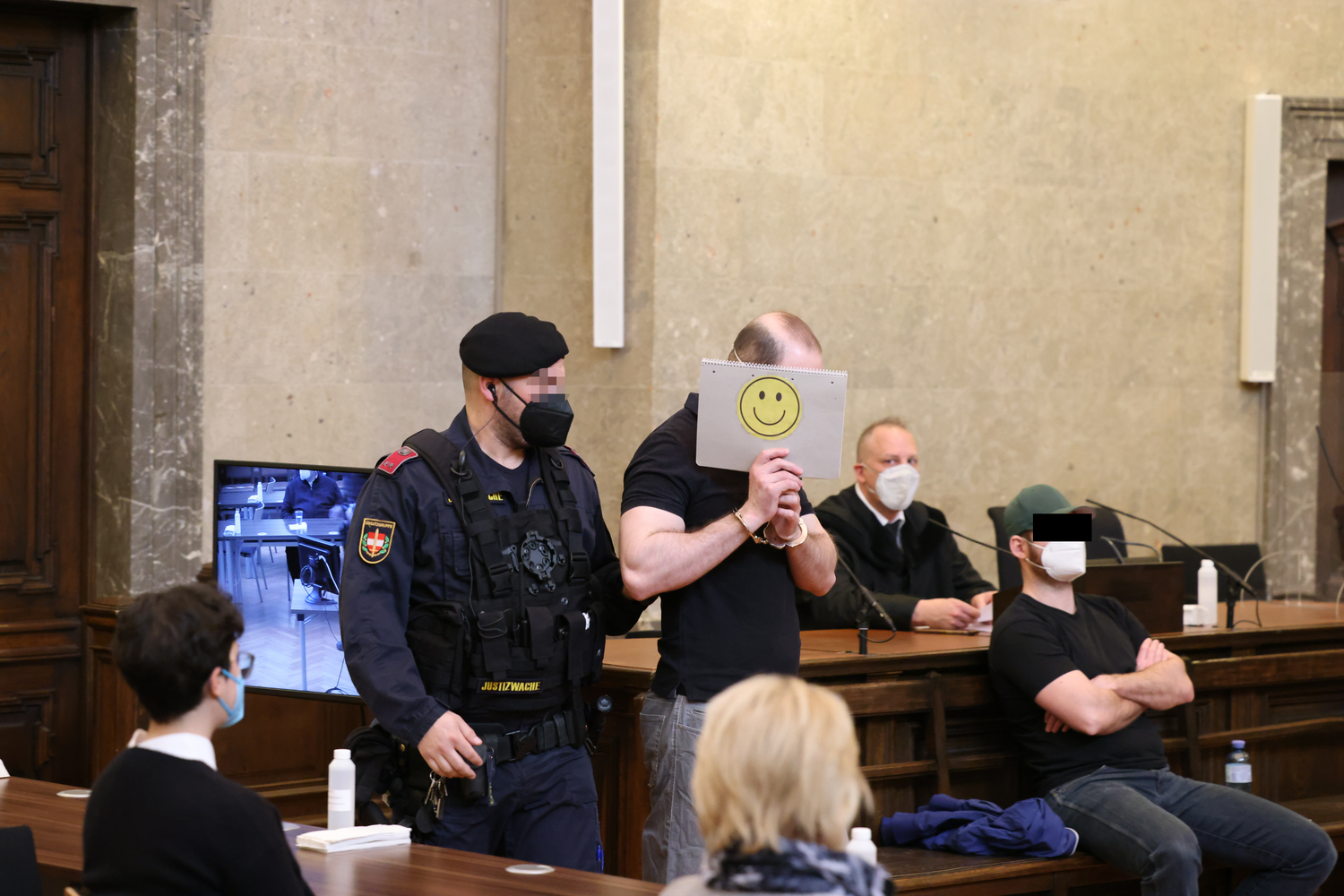 Mr. Bond versteckte sich hinter einem Smiley, rechts sein mitangeklagter Bruder.