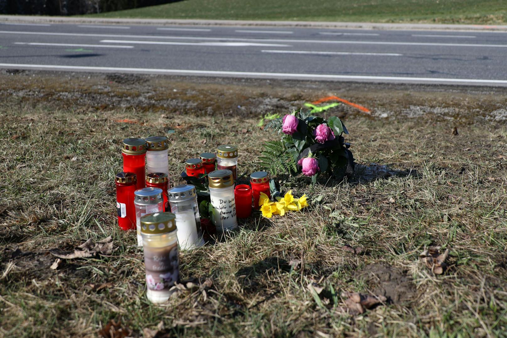 Rund ein Dutzend Kerzen und Blumen stehen an der Unfallstelle.