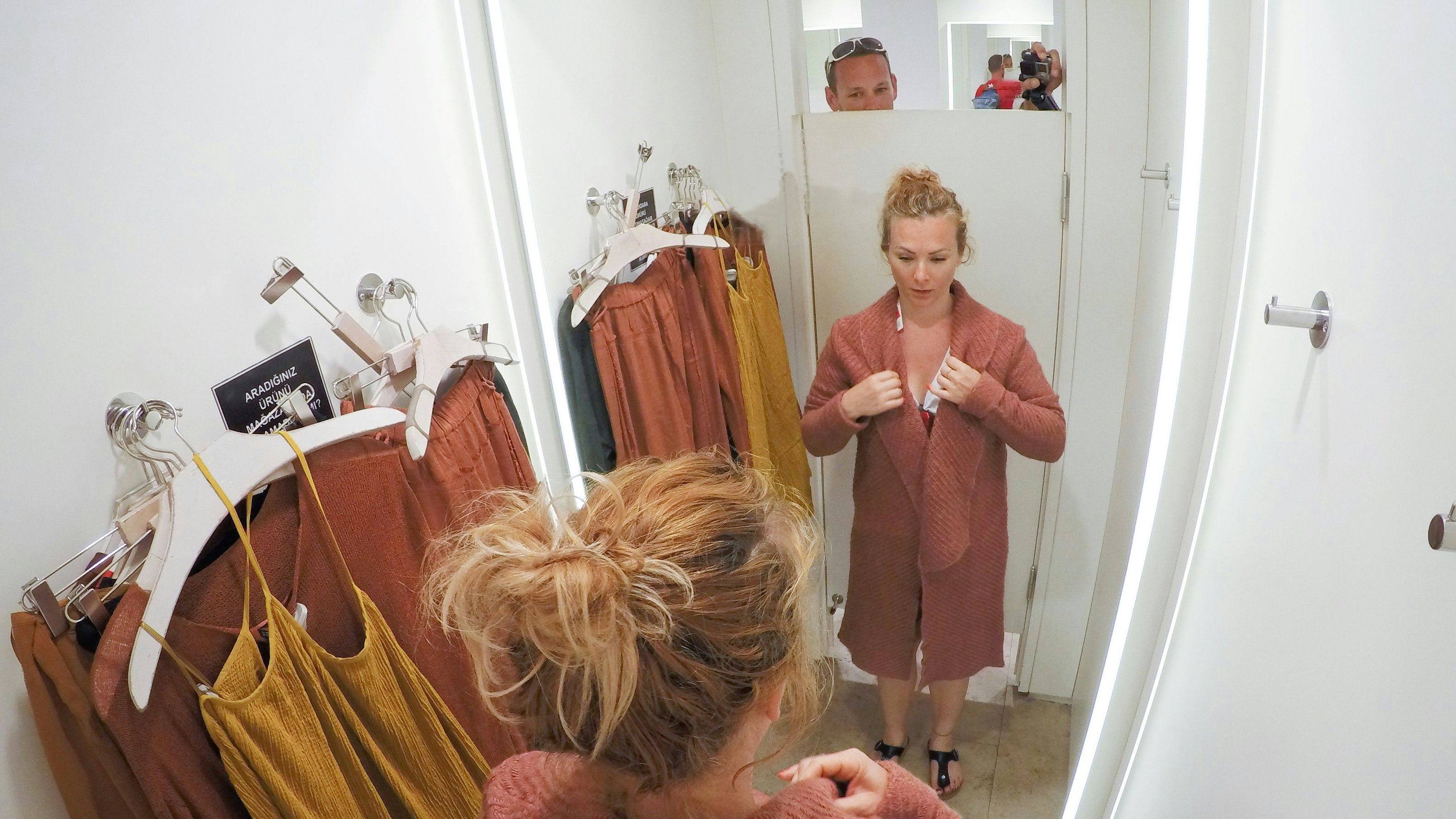 Adult Man Watching Young Woman Changing Clothes in Store's Changing Room.