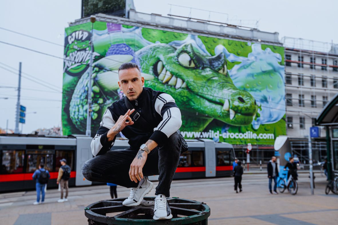 RAF Camora vor seiner Plakatwand in Wien 