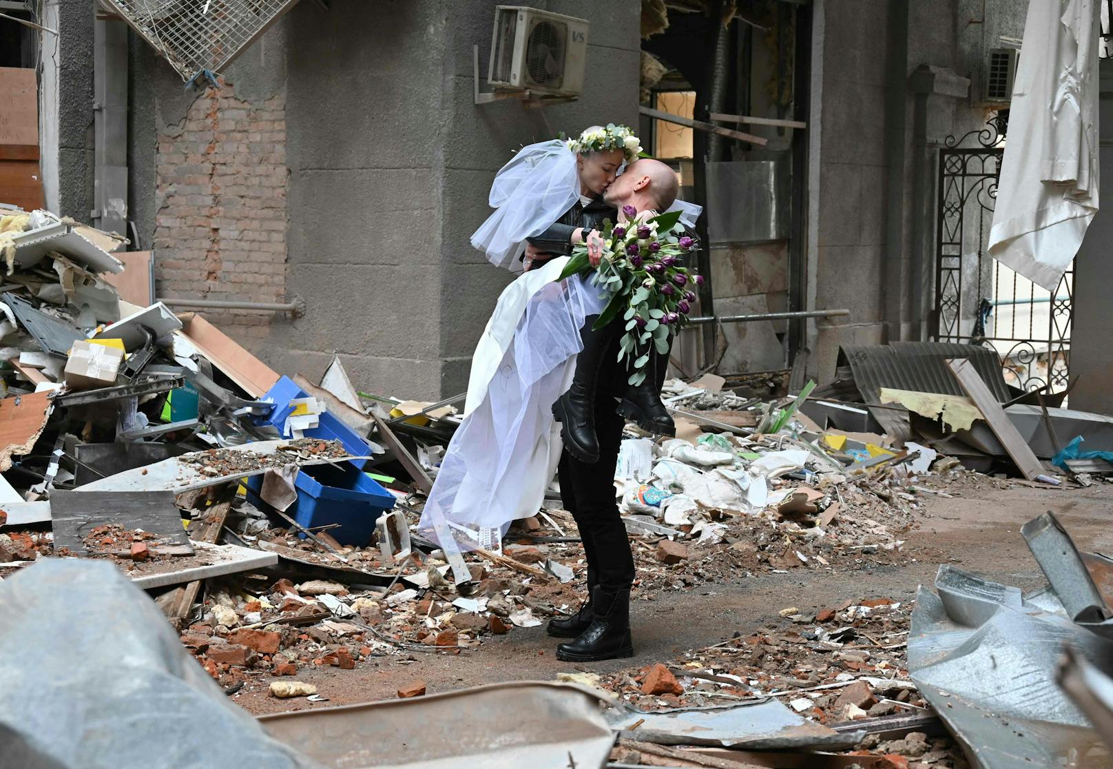 So posieren sie&nbsp;zwischen den Trümmern eines Einkaufs- und Bürokomplexes in der zweitgrößten Stadt der Ukraine.
