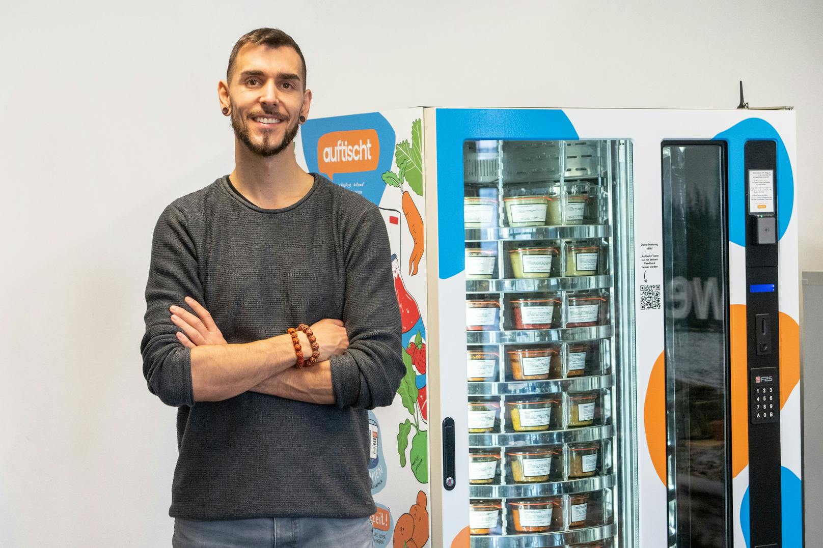 Der Gründer Eric Letourneur steht vor dem Auftischt!-Selbstbedienungsautomaten namens "Gustav" mit BIO-Gerichten, Beilagen, Getränken, Frühstücksartikeln und gesunden Snacks.