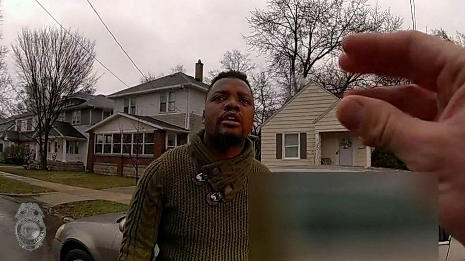 A Grand Rapids Police officer asks Patrick Lyoya if he speaks English, as he stands near a car during a traffic stop, shortly before he was shot dead by the officer during a scuffle on a suburban front lawn in Grand Rapids, Michigan, U.S. April 4, 2022 in a still image from police body camera video. Video taken April 4, 2022.   Grand Rapids Police/Handout via REUTERS   