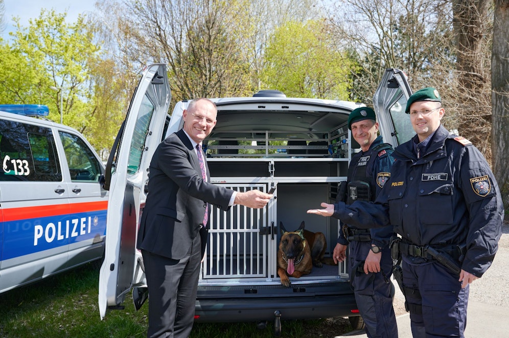 Gerhard Karner (ÖVP) bei der Übergabe der Fahrzeuge. Dem Hund scheint es zu gefallen.
