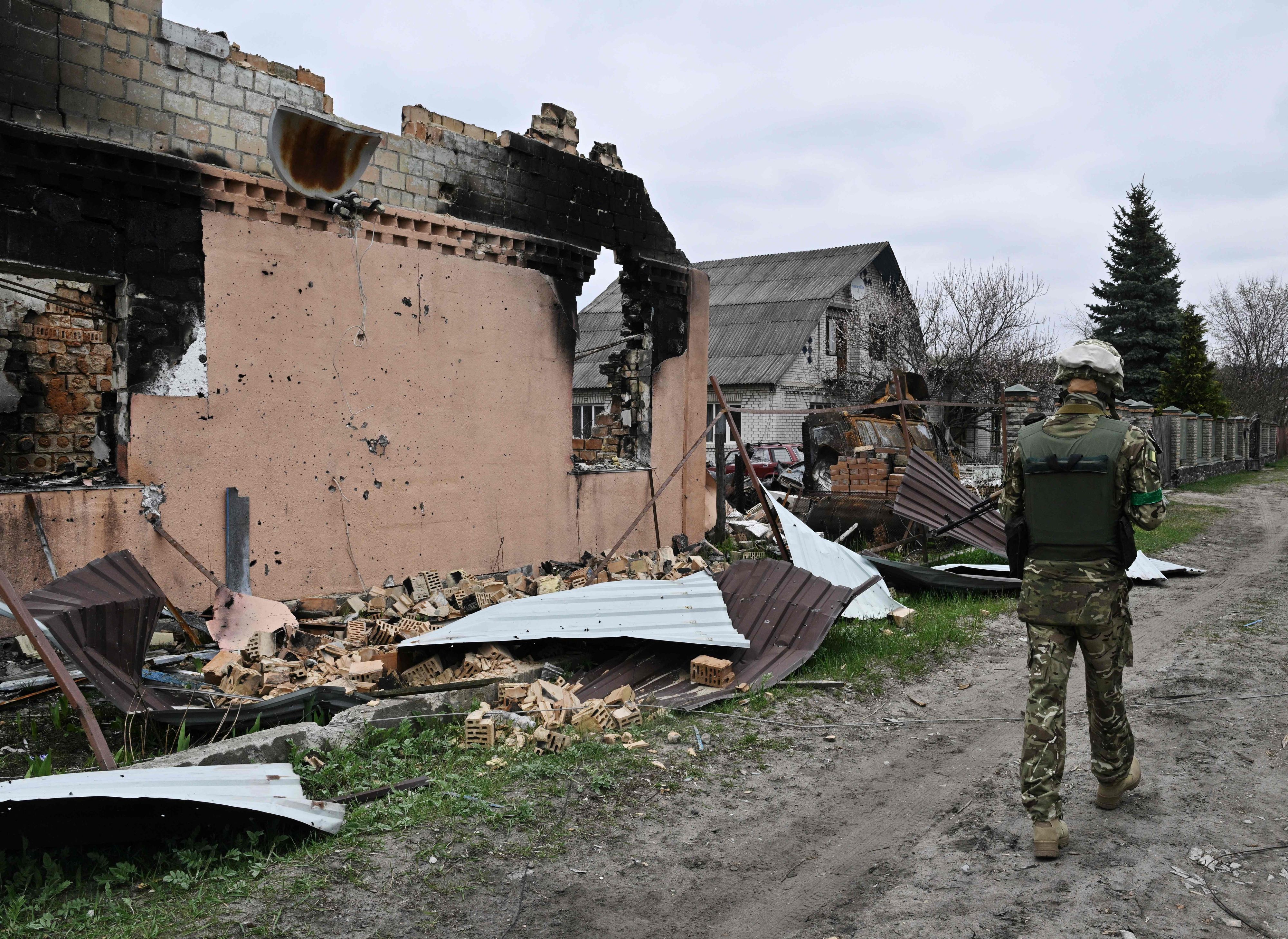 Download von www.picturedesk.com am 21.04.2022 (05:45).  A Ukrainian serviceman walks past a destroyed house in the village of Moshchun, northwest of Kyiv, on April 20, 2022, as more than five million Ukrainians have now fled their country following the Russian invasion, the United Nations says. - UNHCR, the UN refugee agency, says 5,034,439 Ukrainians have left since Russia invaded on February 24. Over a million Ukrainians have in contrast returned to their country since the Russian invasion began, says a spokesman for Kyiv's border force. (Photo by Genya SAVILOV / AFP) - 20220420_PD6569 - Rechteinfo: Rights Managed (RM) Nur für redaktionelle Nutzung! Werbliche Nutzung erfordert Freigabe: bitte schicken Sie uns eine Anfrage.