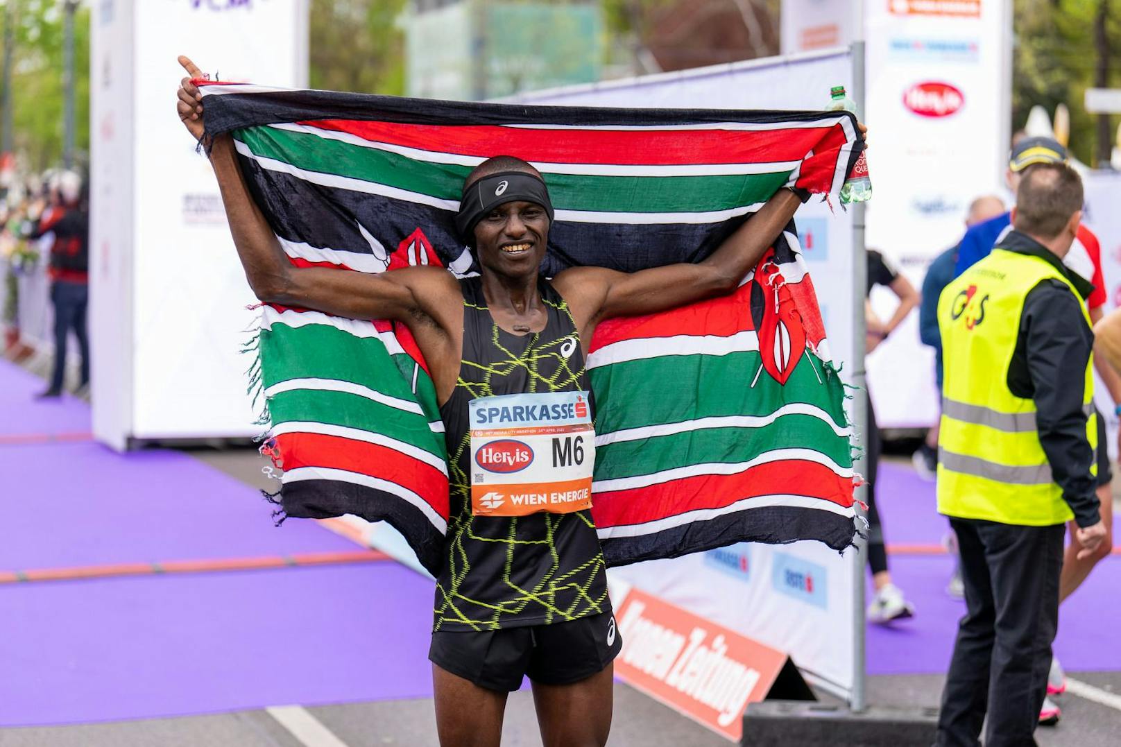 Cosmas Muteti feiert seinen Wien-Sieg mit der Kenia-Flagge.