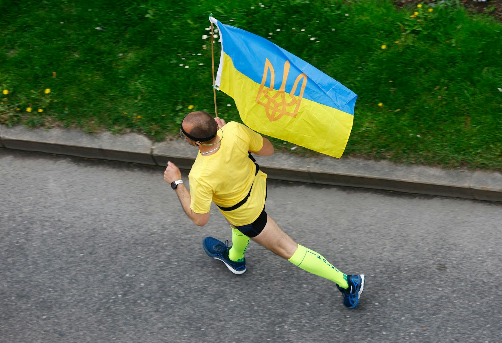 DIeser Läufer setzt in Wien mit seinem Outfit ein Zeichen für die Ukraine.