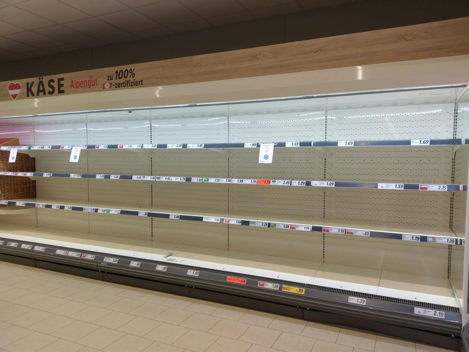 Wiener stehen vor leeren Kühlregalen in Supermarkt