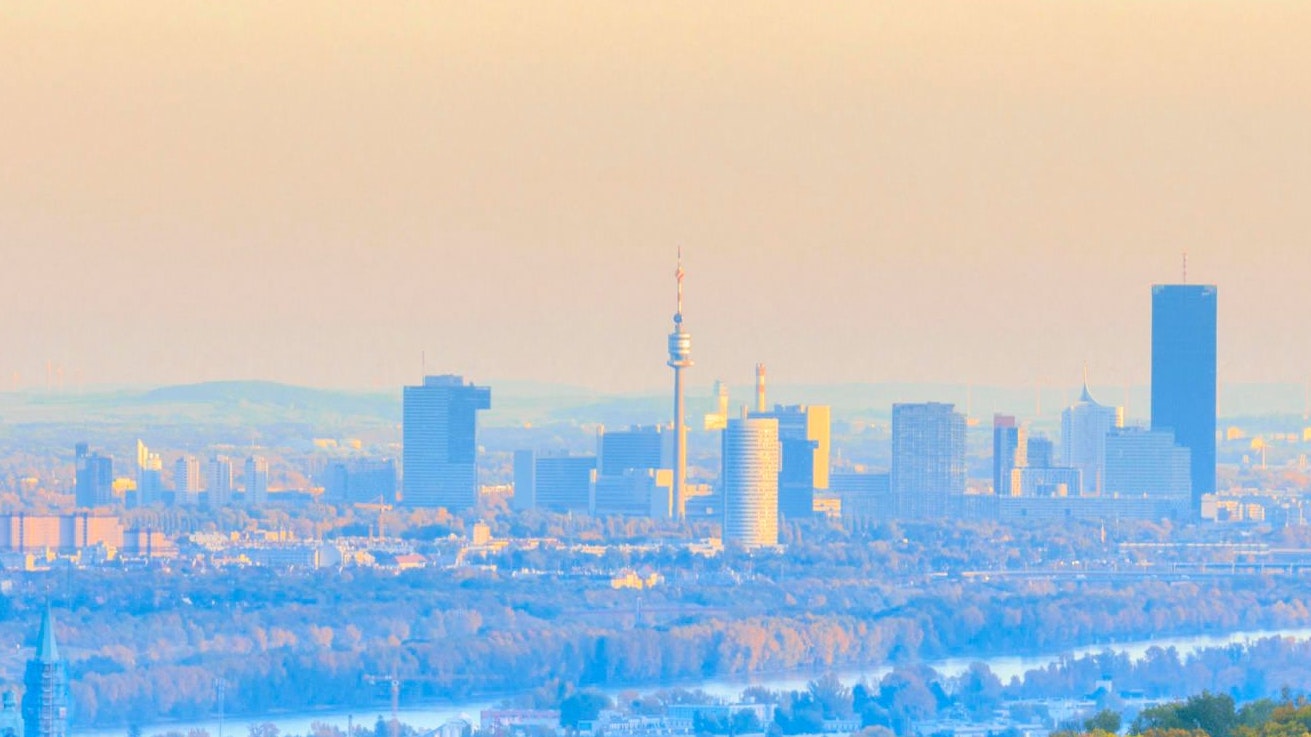 Blick von den Wiesen oberhalb von Kritzendorf, Ortsteil von Klosterneuburg kurz vor Sonnenuntergang an einem strahlenden Herbsttag im Oktober hinaus über Klosterneuburg mit dem Stift und der Pfarrkriche St. Martin und weiter über die Donau hinaus auf die Stadt Wien, rechts der Leopoldsberg.