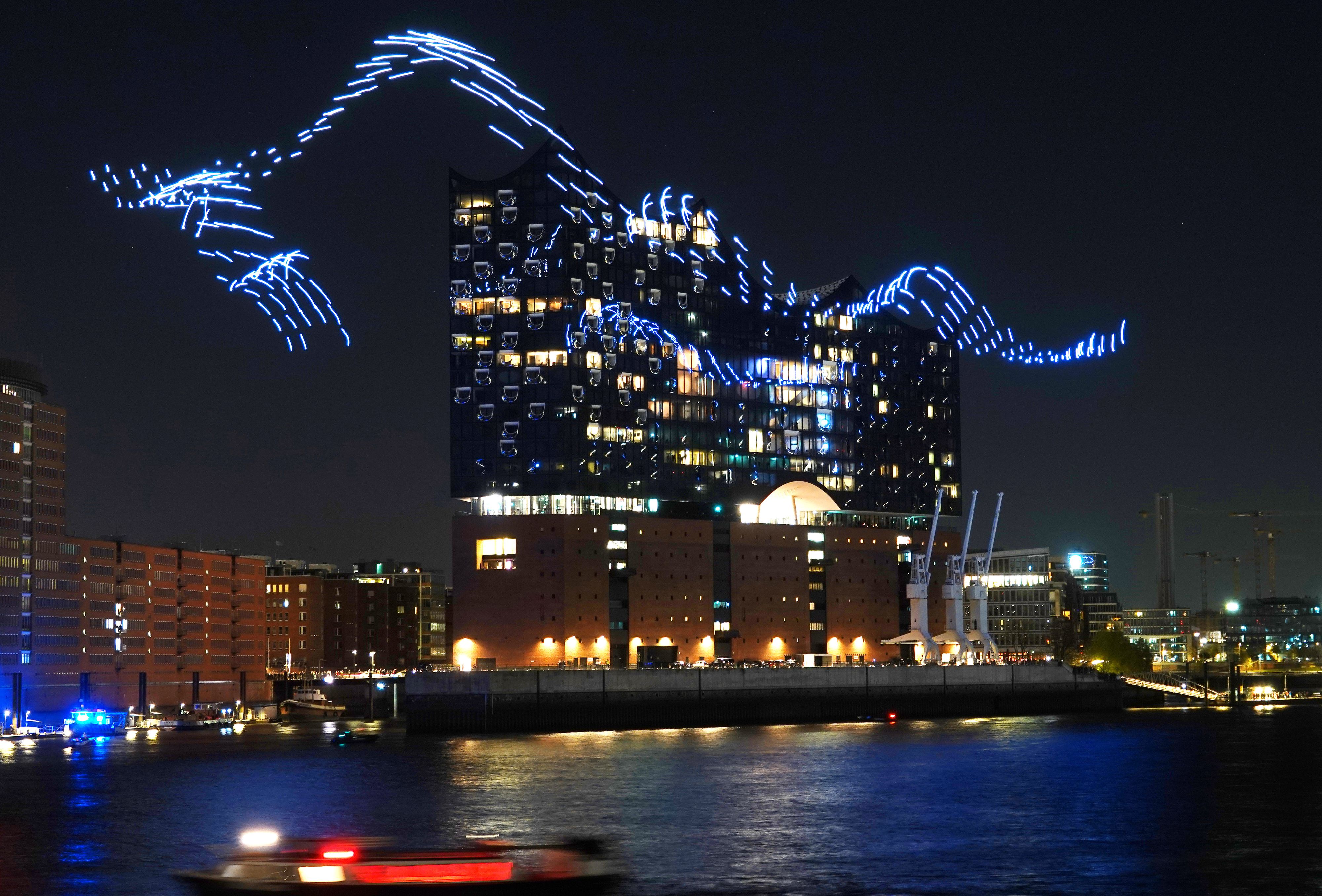 Download von www.picturedesk.com am 02.05.2022 (10:54).  ACT action_38686894 -- Elbphilharmonie: Musikfest startet mit spektakulärer Drohnenballett Lichtshow / 280422 *** .Ein Schwarm aus hunderten beleuchteten Drohnen umspielt - choreographiert zur Musik des zweiten Klavierkonzertes von Thomas Adès  als spektakuläre Lichtinstallation die Elbphilharmonie Hamburg. Dieses visuelle und musikalische Spektakel erwartet Hamburg an den Abenden vom Donnerstag den 28. April bis zum Sonntag den 1. Mai. Die zum fünften Geburtstag der Elbphilharmonie ursprünglich für .den 11. Januar geplante Installation Breaking Waves des niederländischen Künstlerduos DRIFT wird nun zum Start des Internationalen Musikfestes Hamburg im Hamburger Hafen präsentiert.Das kinetische Kunstwerk Breaking Waves rund um die Elbphilharmonie erlebt seine Uraufführung am 28. April um 23:00 Uhr und wird an den drei folgenden Abenden jeweils um 22:30 Uhr wiederholt. Am besten lässt sich das Event aus den umliegenden Hafengebieten oder vom Wasser aus beobachten ____________________________.Local Caption: A swarm of hundreds of illuminated drones - choreographed to the music of the choreographed to the music of the second piano concerto by Thomas Adès. Elbphilharmonie Hamburg as a spectacular light installation. This visual and musical spectacle .and musical spectacle awaits Hamburg on the evenings from Thursday 28 April to Sunday 1 May. Hamburg, Germany - 20220428_PD15106 - Rechteinfo: Rights Managed (RM)