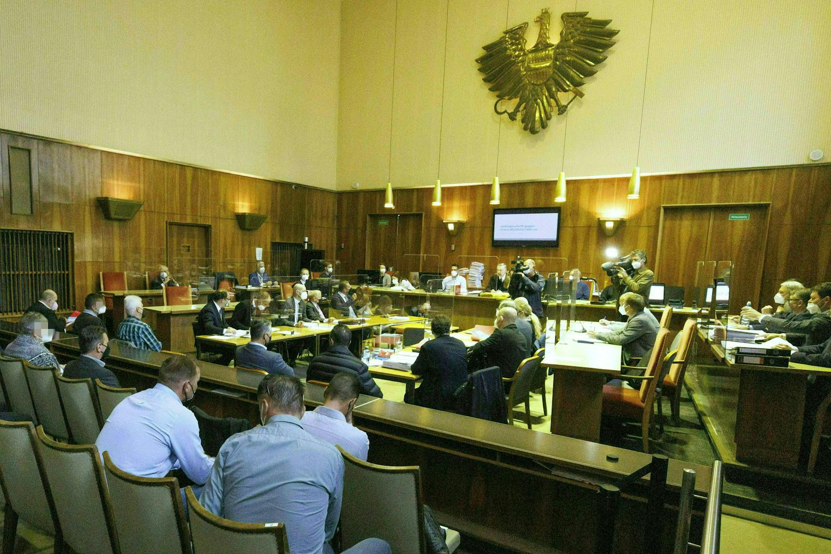 Die Angeklagten (links) und ihre Anwälte (rechts) beim Prozessauftakt in Graz