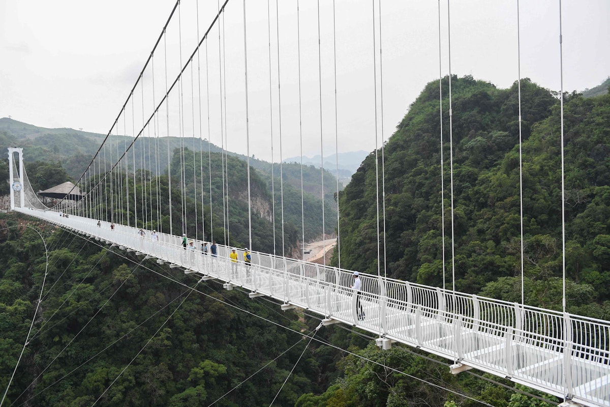 Download von www.picturedesk.com am 03.05.2022 (15:01).  TOPSHOT - Visitors walk on the Bach Long glass bridge in Moc Chau district in Vietnam's Son La province on April 29, 2022. - Vietnam launched a new attraction for tourists -- with a head for heights -- on April 29 with the opening of a glass-bottomed bridge suspended some 150 metres above a lush, jungle-clad gorge. (Photo by Nhac NGUYEN / AFP) - 20220429_PD4102 - Rechteinfo: Rights Managed (RM) Nur für redaktionelle Nutzung! Werbliche Nutzung erfordert Freigabe: bitte schicken Sie uns eine Anfrage.